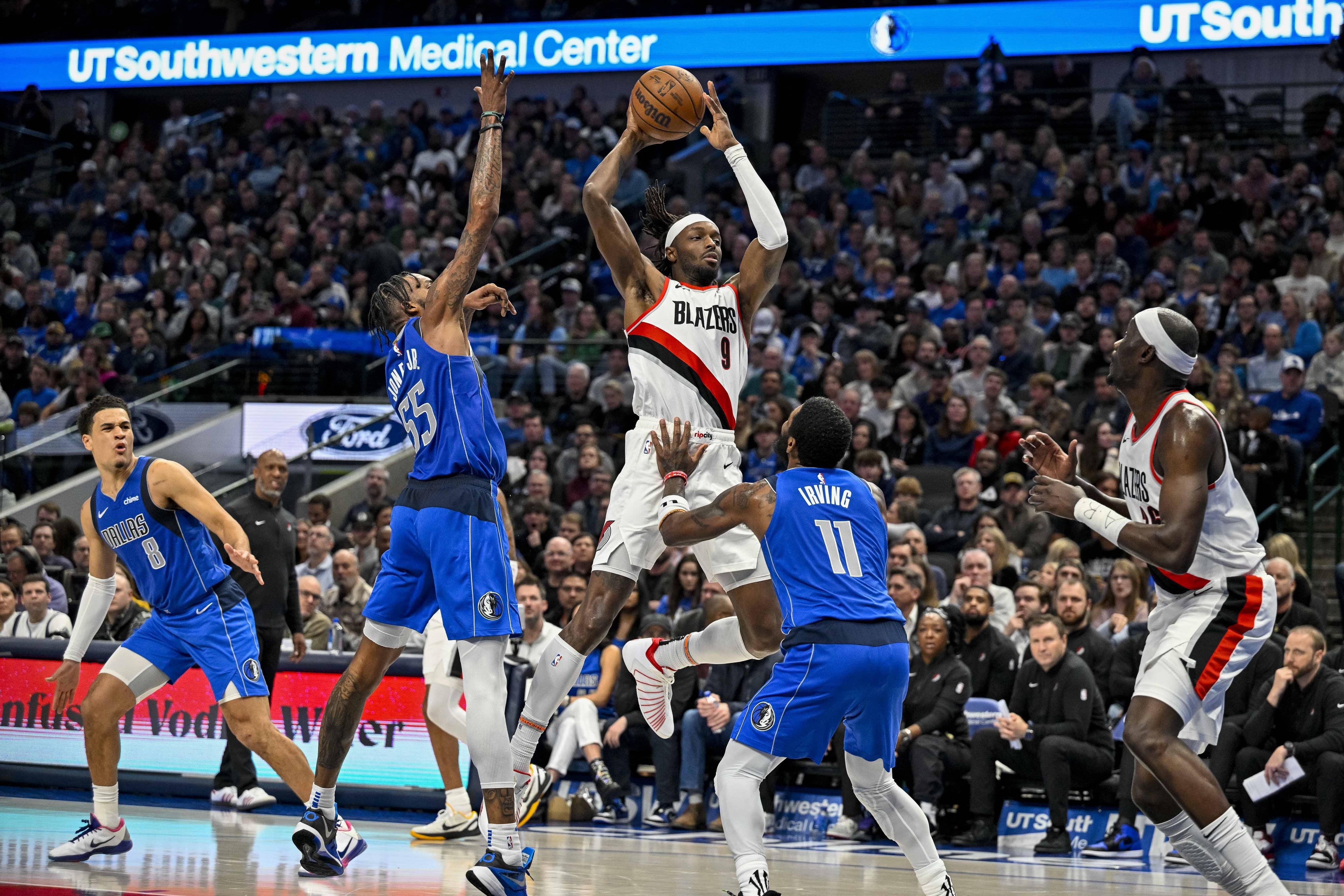 Jan 5, 2024; Dallas, Texas, USA; Portland Trail Blazers forward Jerami Grant (9) passes the ball over Dallas Mavericks forward Derrick Jones Jr. (55) and guard Kyrie Irving (11) during the second quarter at the American Airlines Center. Mandatory Credit: Jerome Miron-Imagn Images