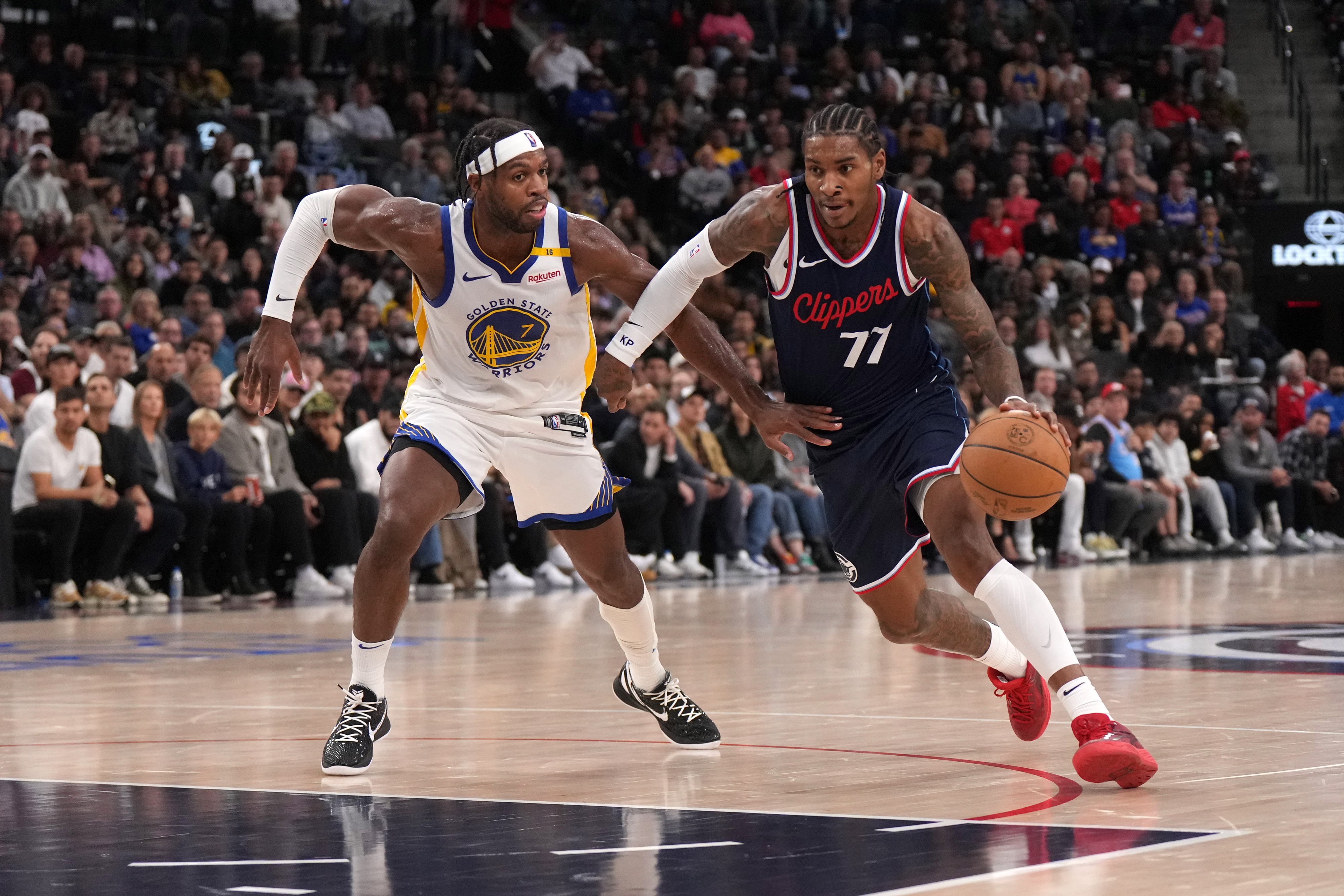 Nov 18, 2024; Inglewood, California, USA; LA Clippers guard Kevin Porter Jr. (77) dribbles the ball against Golden State Warriors guard Buddy Hield (7) in the second half at Intuit Dome. Mandatory Credit: Kirby Lee-Imagn Images