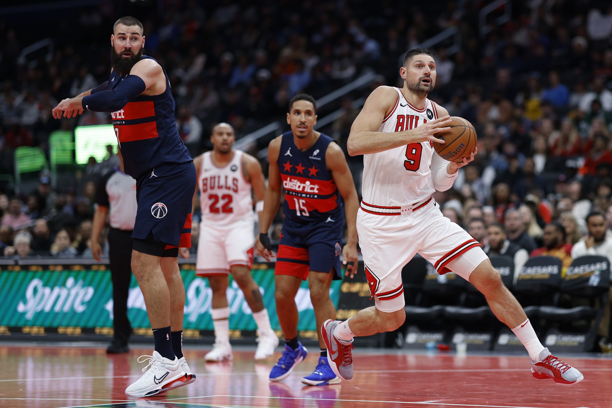 Nov 26, 2024; Washington, District of Columbia, USA; Chicago Bulls center Nikola Vucevic (9) drives to the basket past Washington Wizards center Jonas Valanciunas (17) in the fourth quarter at Capital One Arena. Mandatory Credit: Geoff Burke-Imagn Images