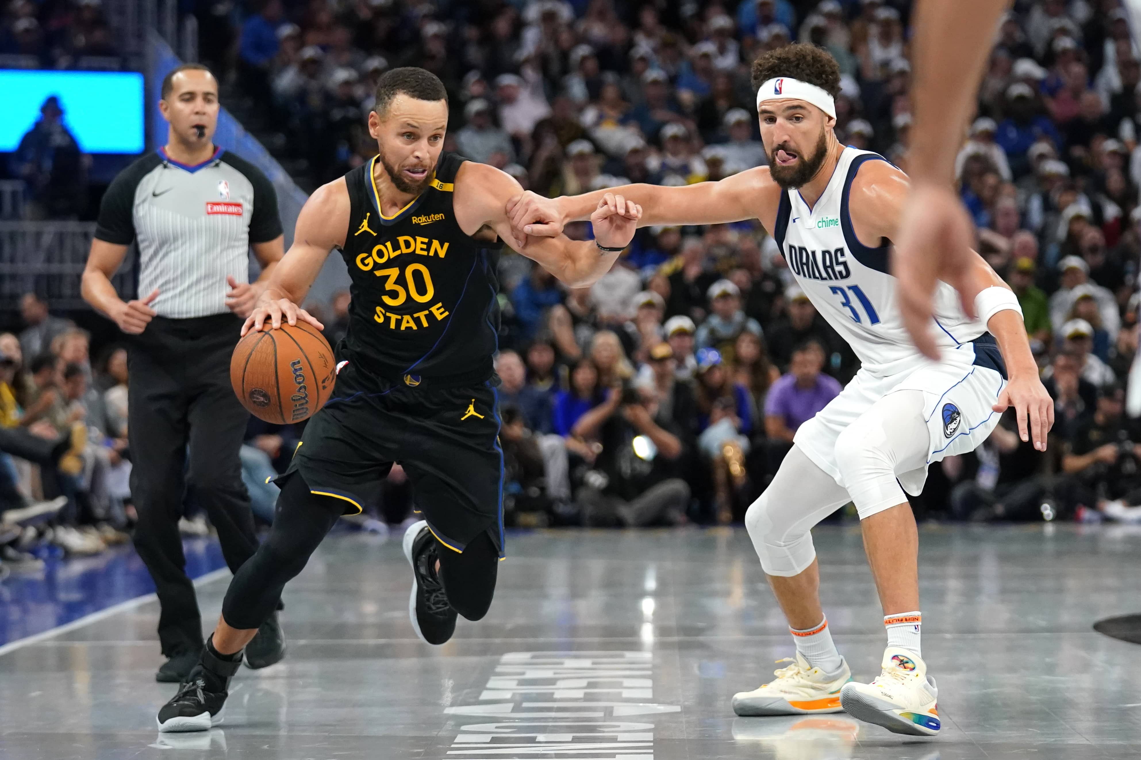 Nov 12, 2024; San Francisco, California, USA; Golden State Warriors guard Stephen Curry (30) dribbles past Dallas Mavericks guard Klay Thompson (31) in the fourth quarter at the Chase Center.