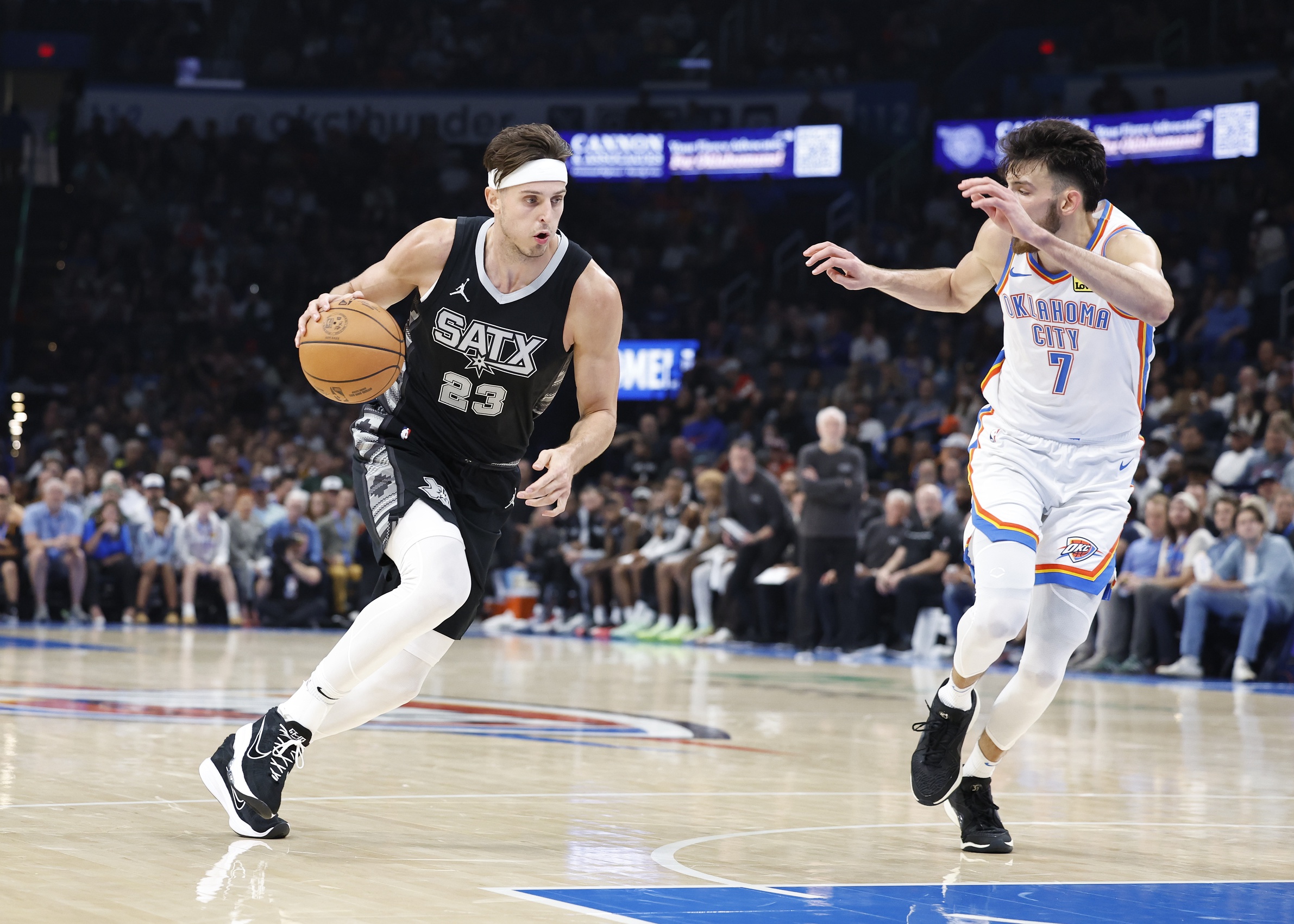 Oct 30, 2024; Oklahoma City, Oklahoma, USA; San Antonio Spurs forward Zach Collins (23) drives to the basket beside Oklahoma City Thunder forward Chet Holmgren (7) during the second quarter at Paycom Center.