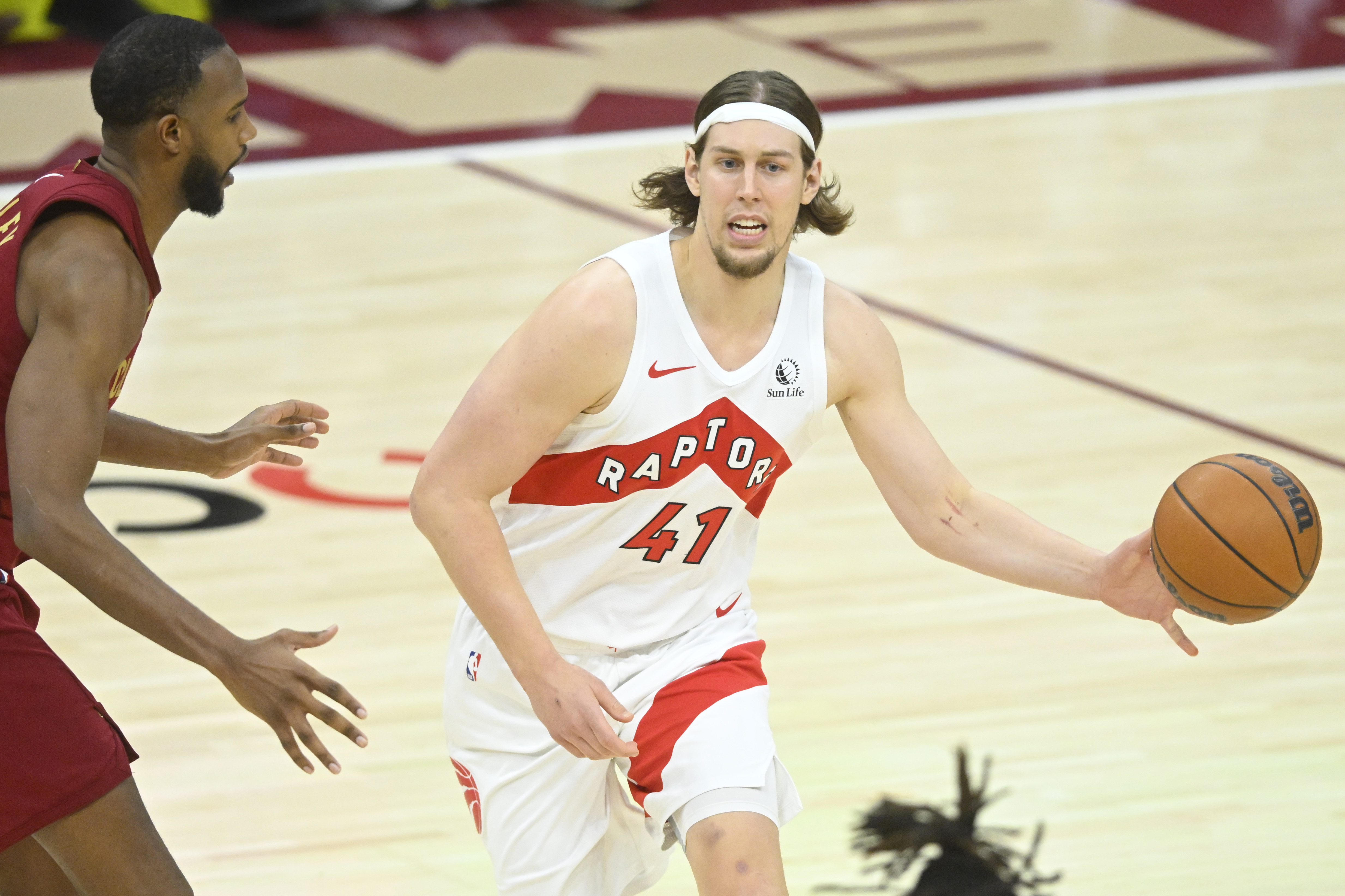 Jan 9, 2025; Cleveland, Ohio, USA; Toronto Raptors forward Kelly Olynyk (41) throws a pass beside Cleveland Cavaliers forward Evan Mobley (4) in the third quarter at Rocket Mortgage FieldHouse. Mandatory Credit: David Richard-Imagn Images