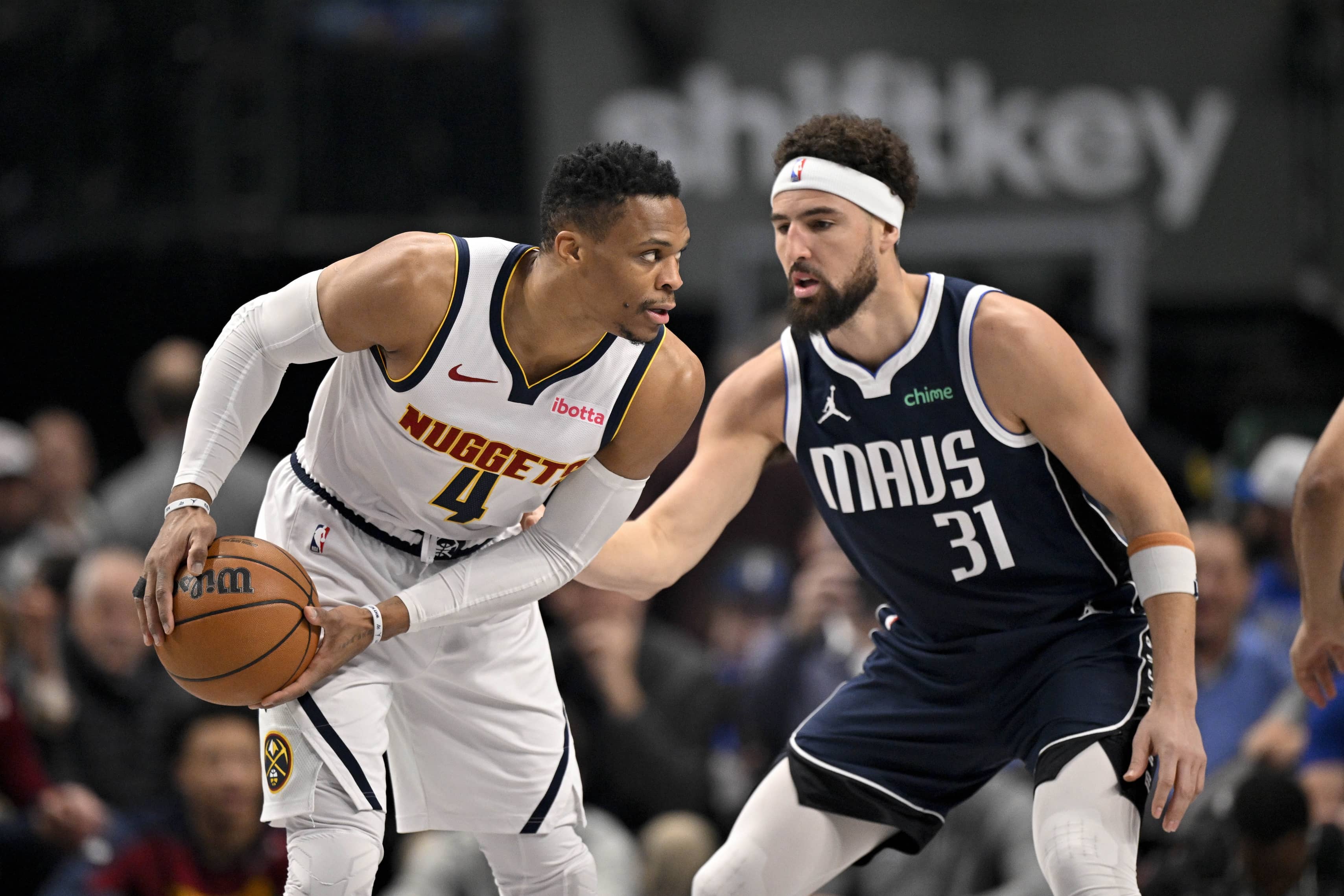 Jan 12, 2025; Dallas, Texas, USA; Denver Nuggets guard Russell Westbrook (4) looks to moves the ball past Dallas Mavericks guard Klay Thompson (31) during the first quarter at the American Airlines Center. Mandatory Credit: Jerome Miron-Imagn Images  