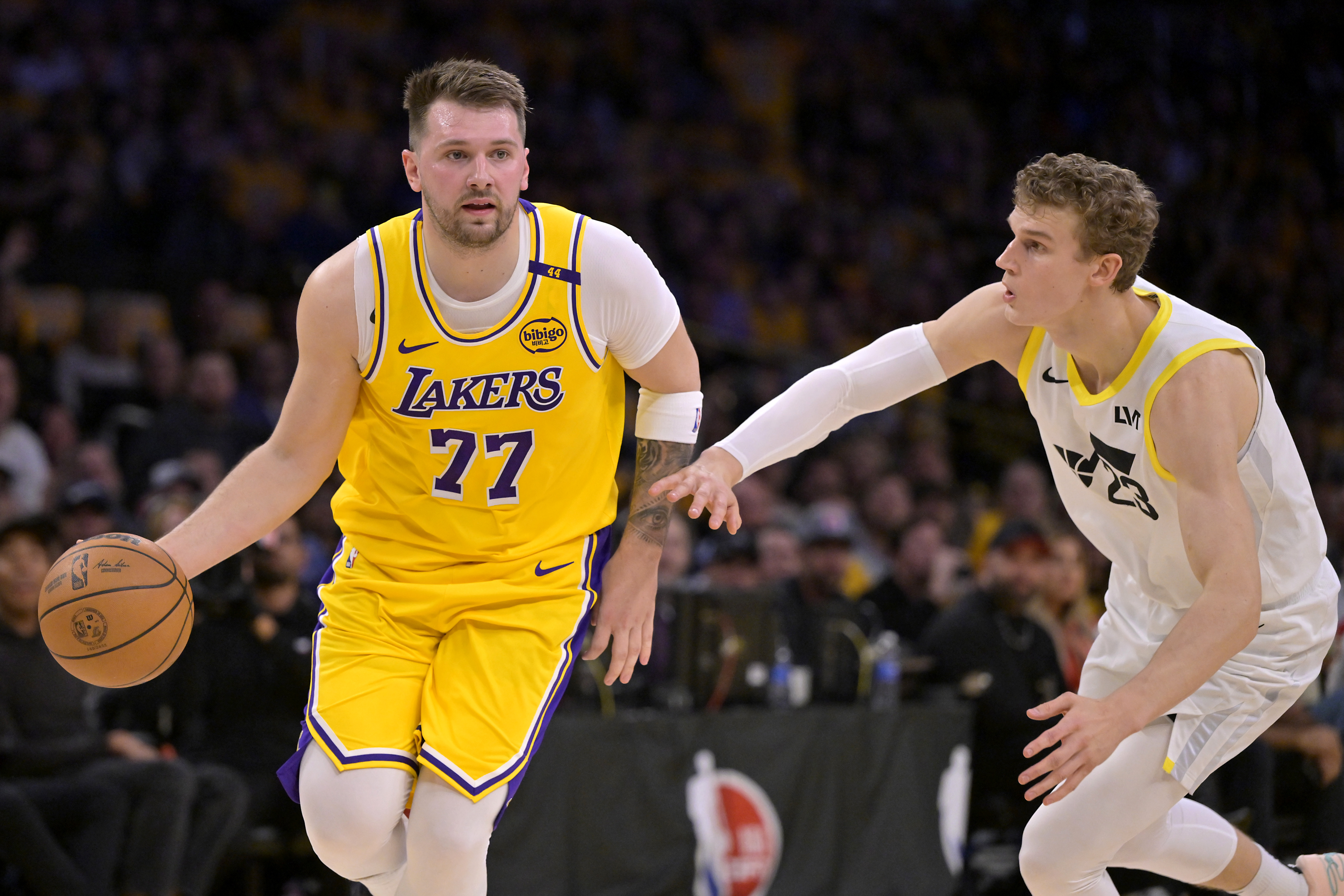 Feb 10, 2025; Los Angeles, California, USA; Los Angeles Lakers guard Luka Doncic (77) is defended by Utah Jazz forward Lauri Markkanen (23) in the first quarter at Crypto.com Arena. Mandatory Credit: Jayne Kamin-Oncea-Imagn Images  