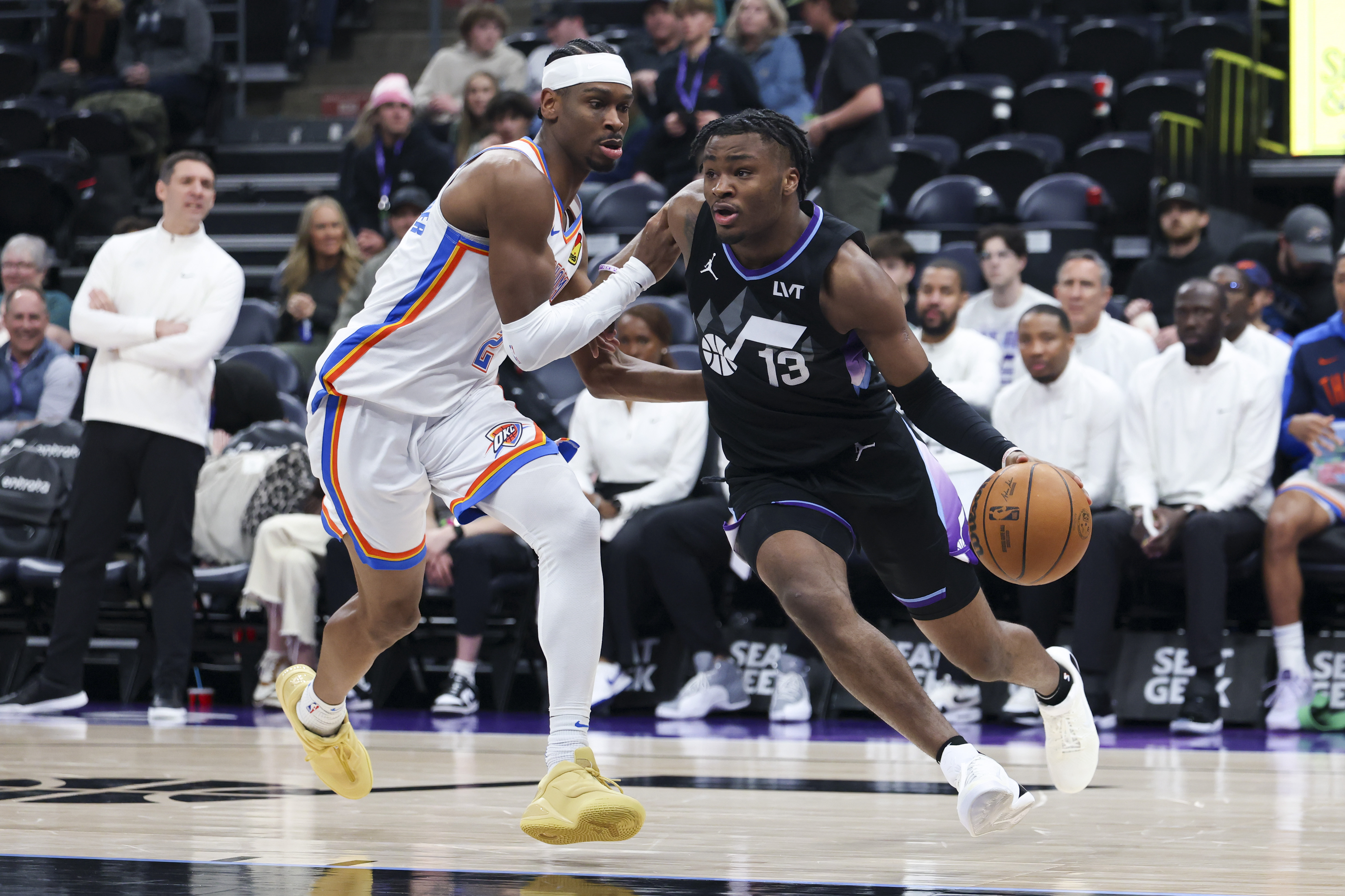 Feb 21, 2025; Salt Lake City, Utah, USA; Utah Jazz guard Isaiah Collier (13) drives against Oklahoma City Thunder guard Shai Gilgeous-Alexander (2) during the third quarter at Delta Center. Mandatory Credit: Rob Gray-Imagn Images  