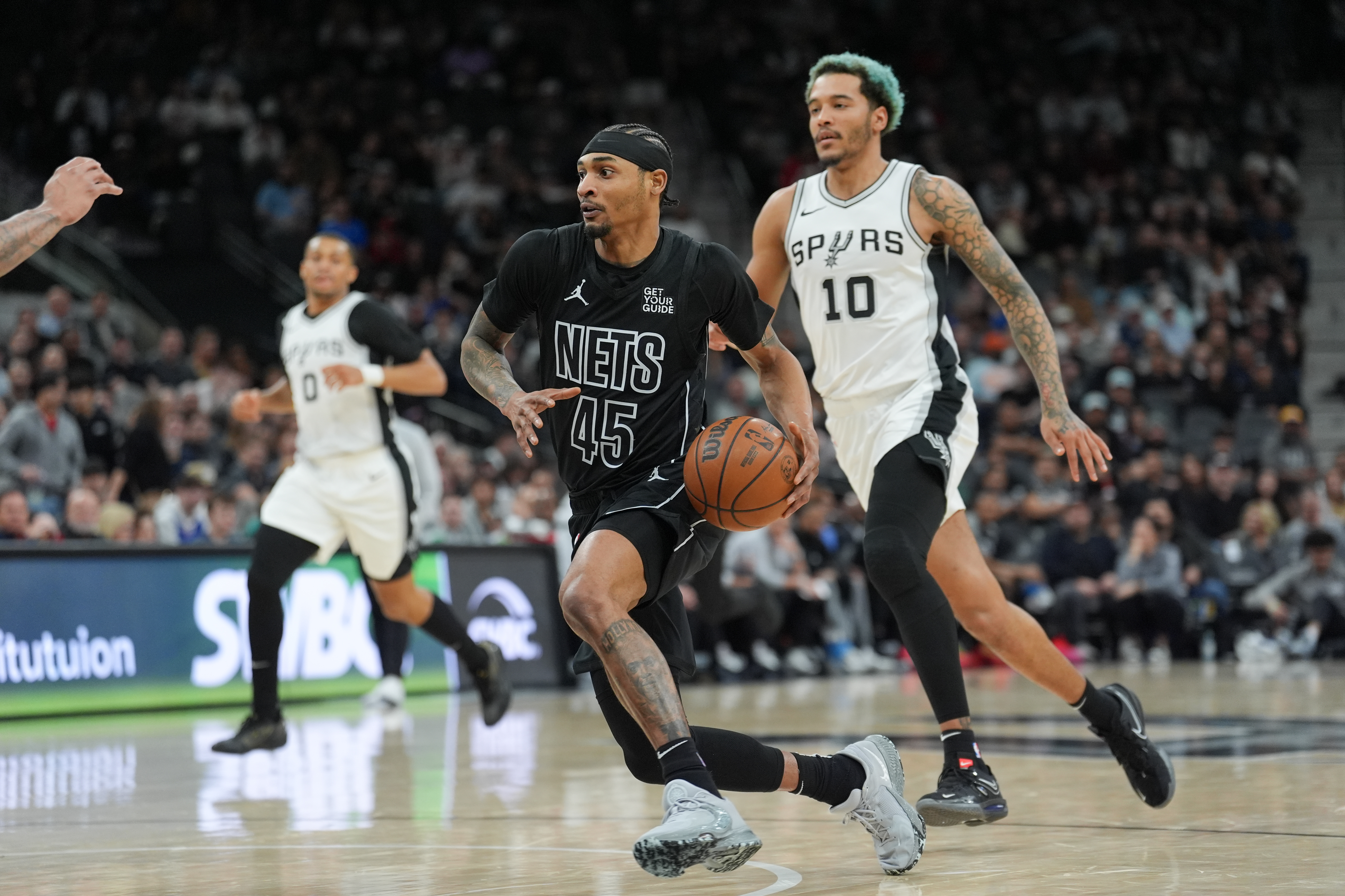 Mar 4, 2025; San Antonio, Texas, USA; Brooklyn Nets guard Keon Johnson (45) dribbles in front of San Antonio Spurs forward Jeremy Sochan (10) in the second half at Frost Bank Center. Mandatory Credit: Daniel Dunn-Imagn Images  