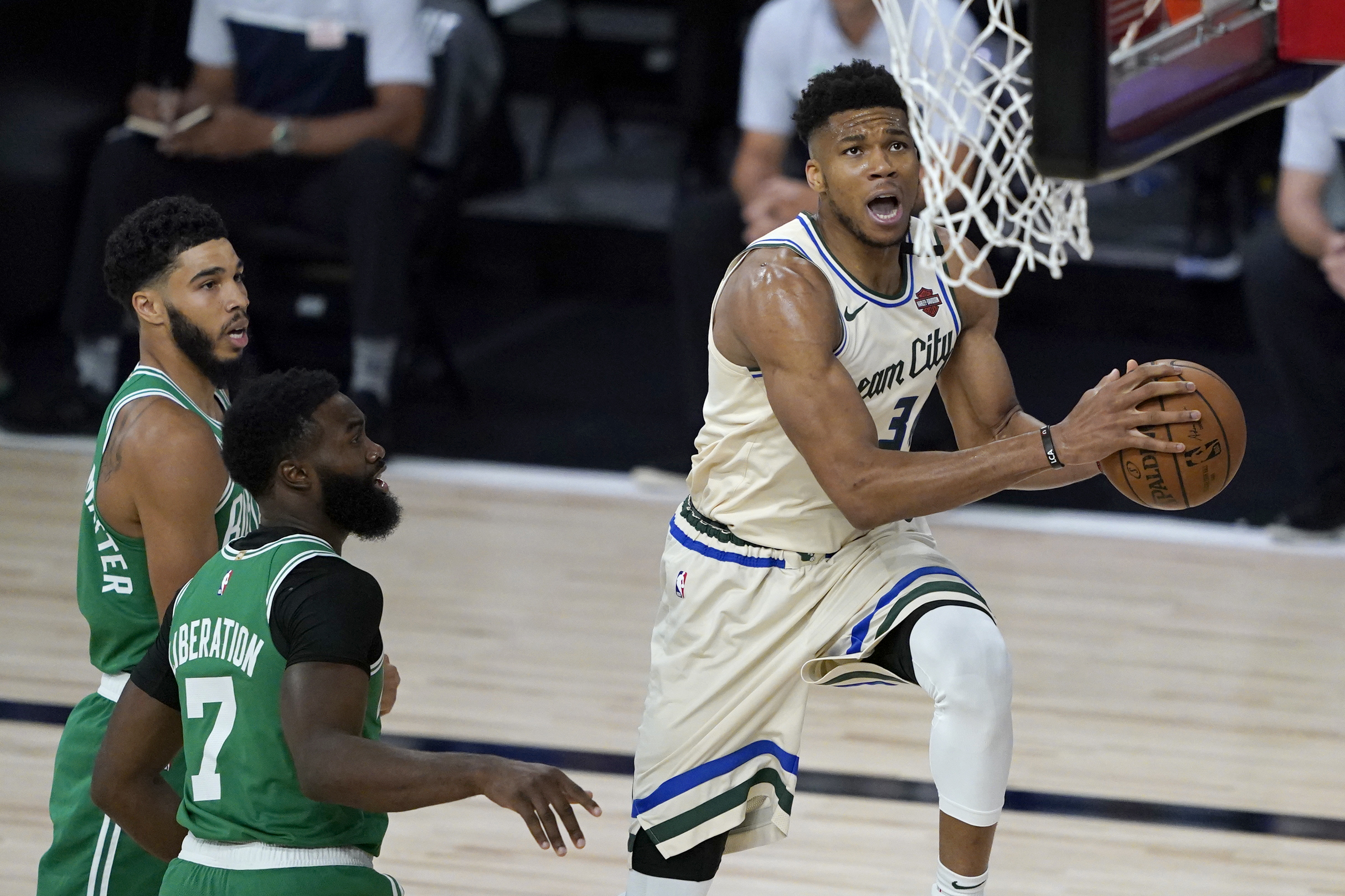 July 31, 2020; Lake Buena Vista, USA; Milwaukee Bucks' Giannis Antetokounmpo, right, heads to the basket past Boston Celtics' Jaylen Brown (7) during the first half of an NBA basketball game Friday, July 31, 2020, in Lake Buena Vista, Fla. Mandatory Credit: Ashley Landis/Pool Photo via Imagn Images  