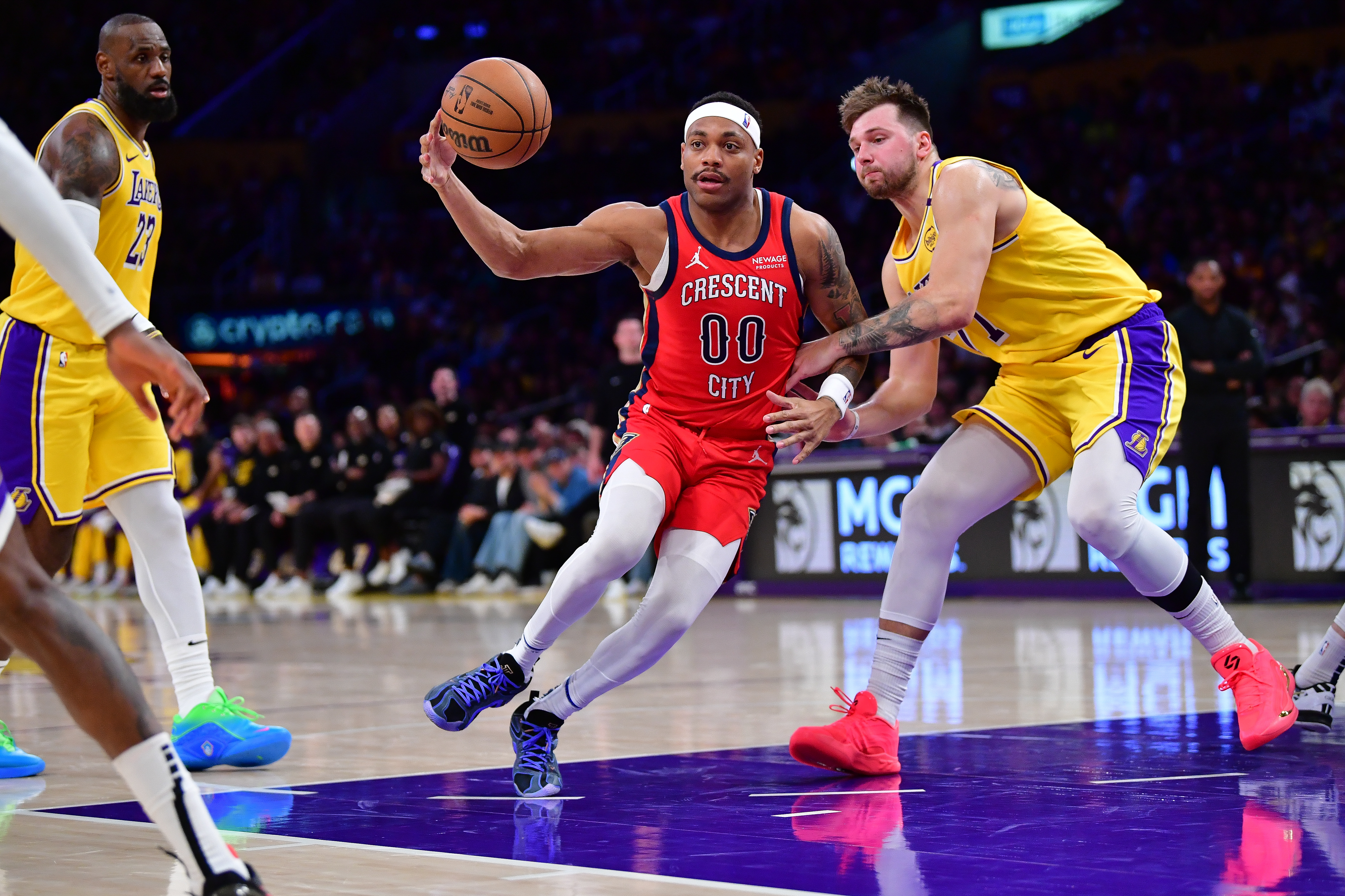 Mar 4, 2025; Los Angeles, California, USA; New Orleans Pelicans forward Bruce Brown (00) moves the ball against Los Angeles Lakers guard Luka Doncic (77) during the second half at Crypto.com Arena. Mandatory Credit: Gary A. Vasquez-Imagn Images  
