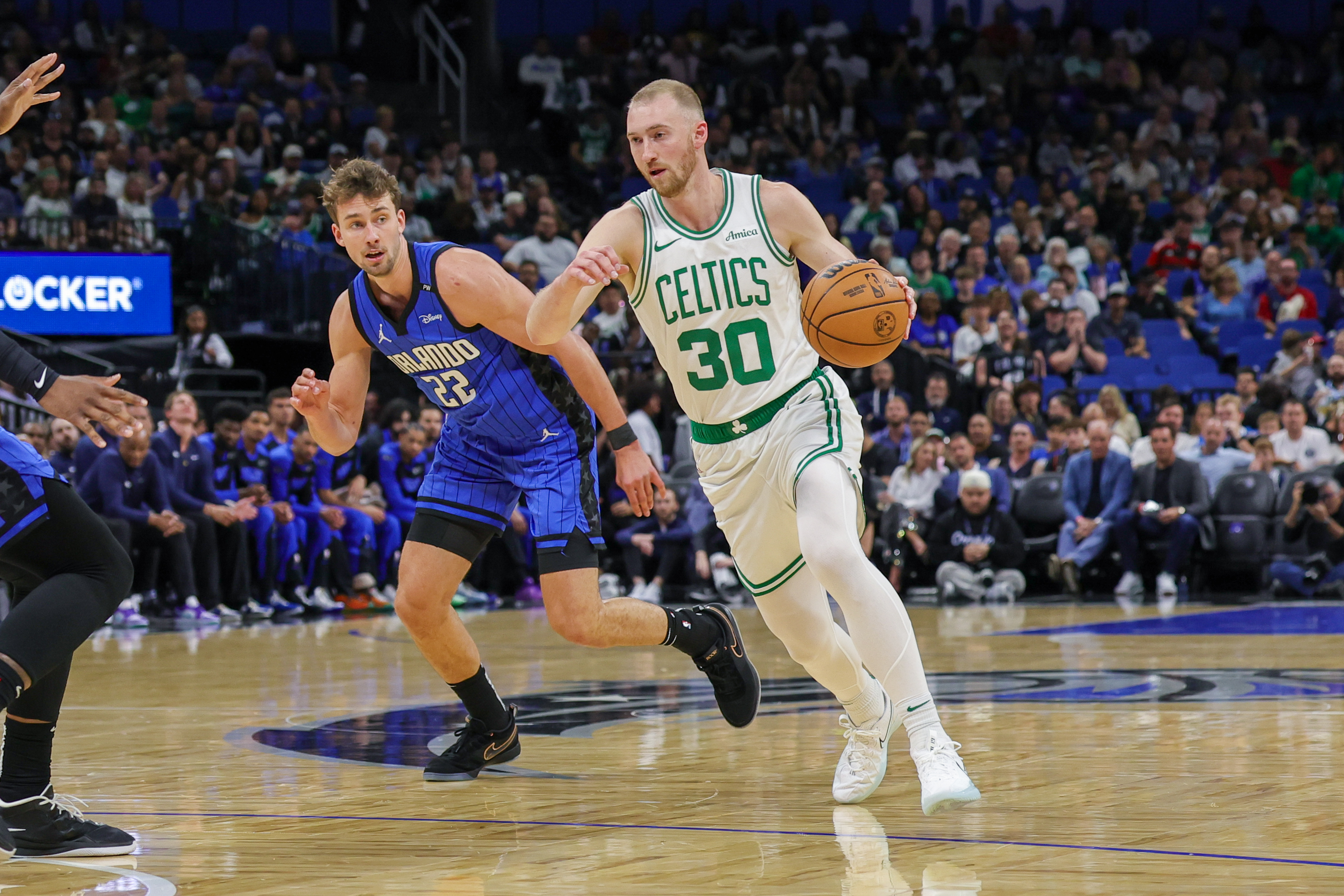 Apr 9, 2025; Orlando, Florida, USA; Boston Celtics forward Sam Hauser (30) brings the ball up court in front of Orlando Magic forward Franz Wagner (22) during the first quarter at Kia Center. Mandatory Credit: Mike Watters-Imagn Images  