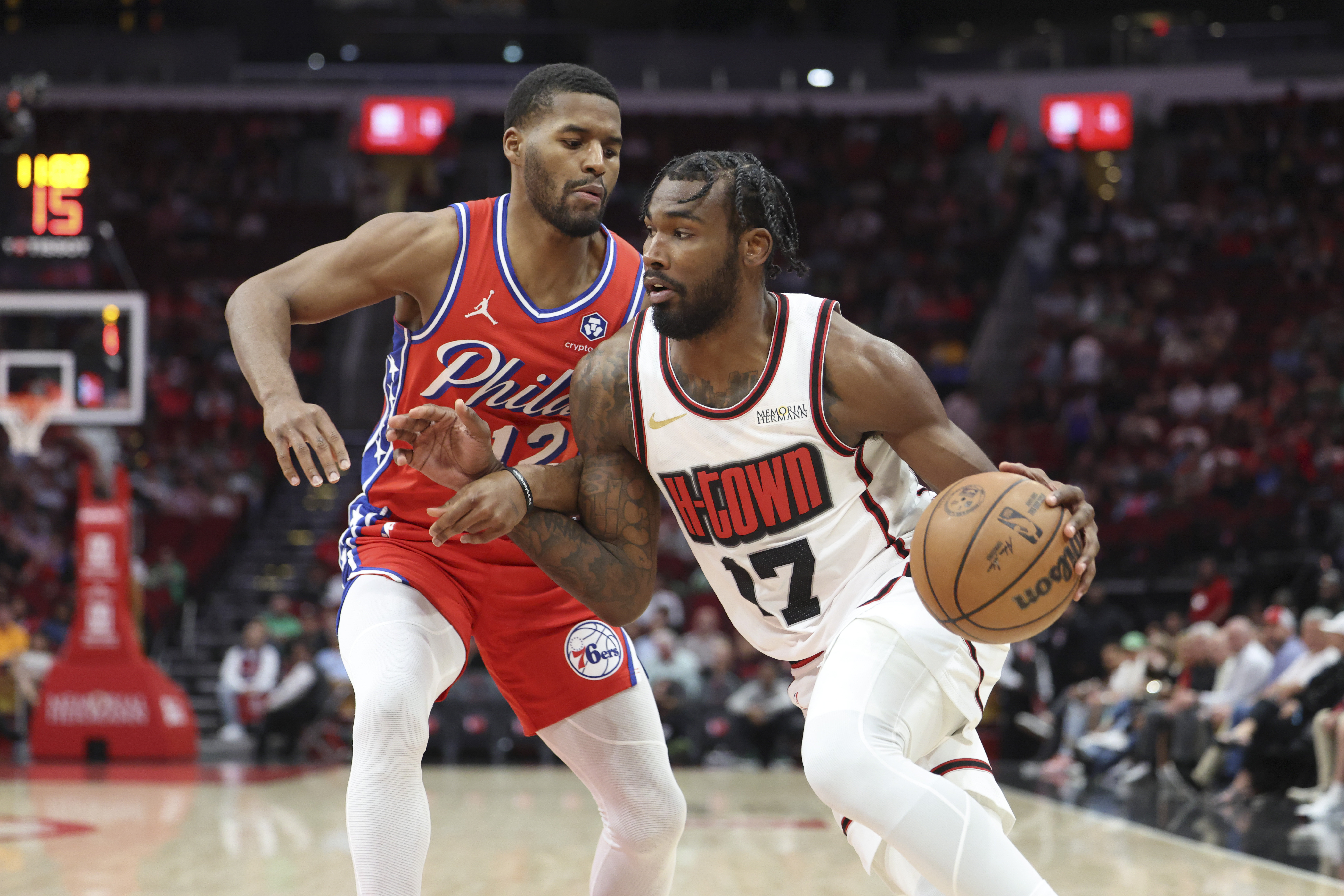 Mar 17, 2025; Houston, Texas, USA; Houston Rockets forward Tari Eason (17) drives with the ball as Philadelphia 76ers guard Jared Butler (12) defends during the first quarter at Toyota Center. Mandatory Credit: Troy Taormina-Imagn Images  