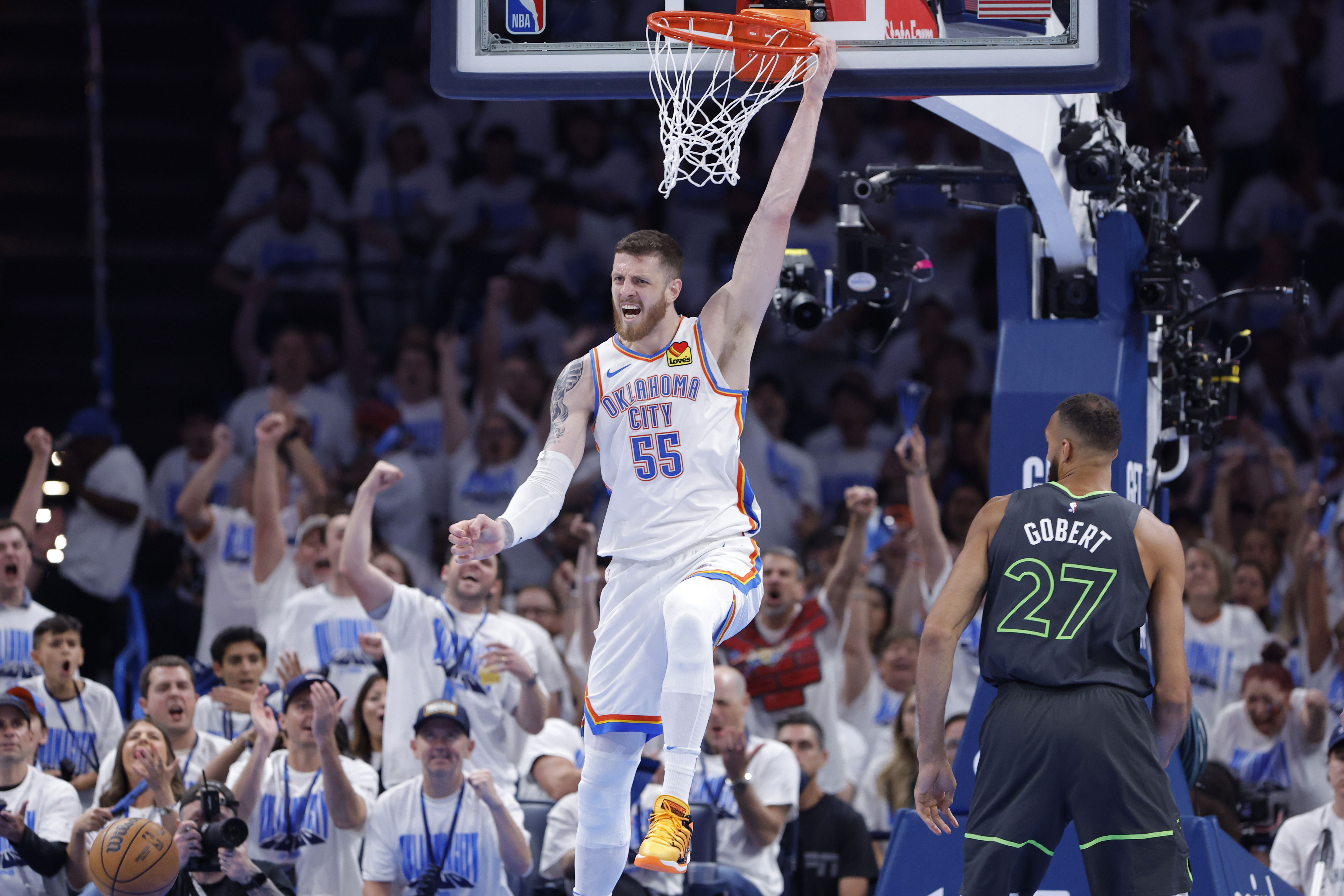 May 20, 2025; Oklahoma City, Oklahoma, USA; Oklahoma City Thunder center Isaiah Hartenstein (55) dunks against Minnesota Timberwolves center Rudy Gobert (27) in the second quarter during game one of the western conference finals for the 2025 NBA Playoffs at Paycom Center. Mandatory Credit: Alonzo Adams-Imagn Images
