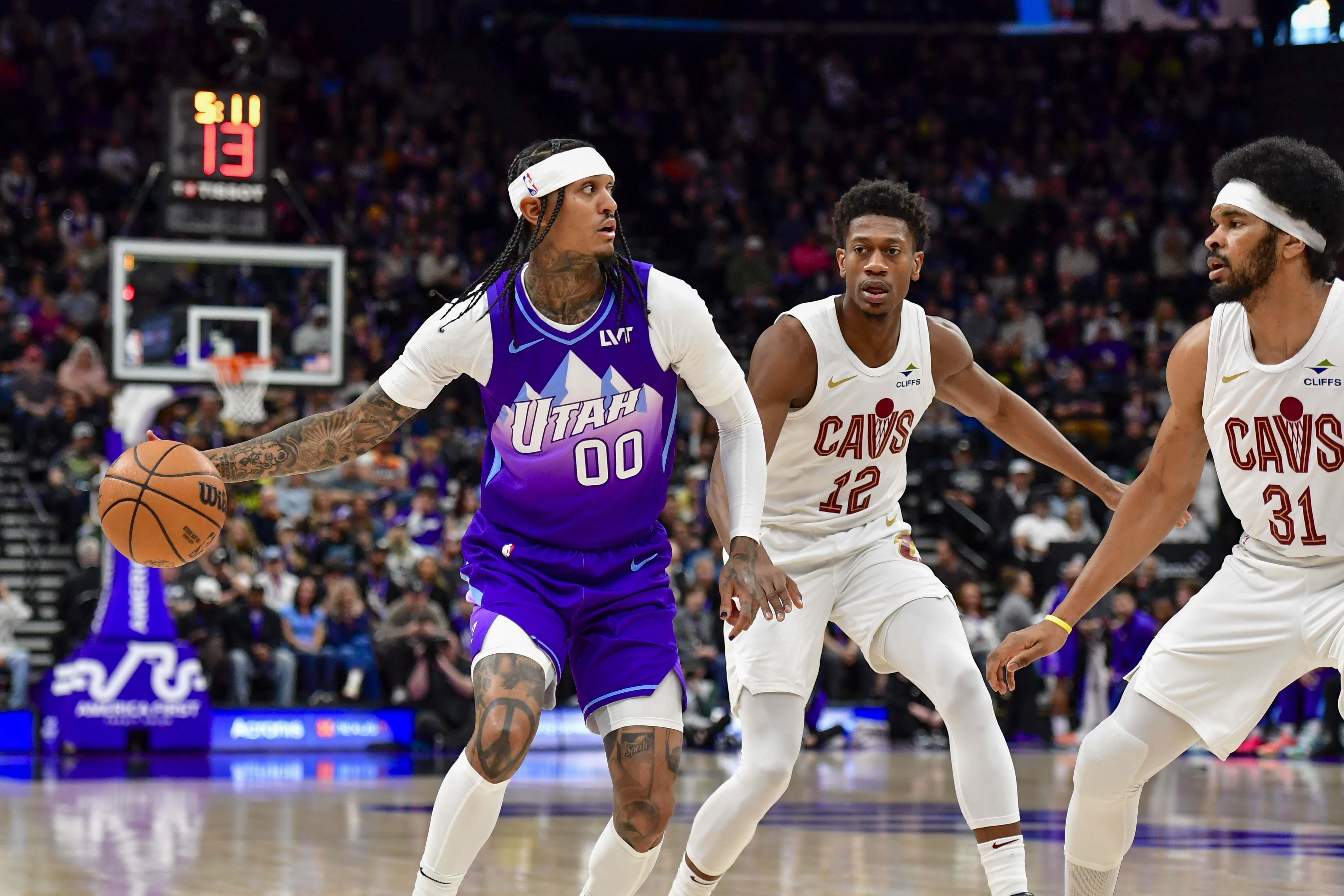 Mar 23, 2025; Salt Lake City, Utah, USA; Utah Jazz guard Jordan Clarkson (00) looks to pass against Cleveland Cavaliers forward/guard De'Andre Hunter (12) during the first half at Delta Center. Mandatory Credit: Peter Creveling-Imagn Images  
