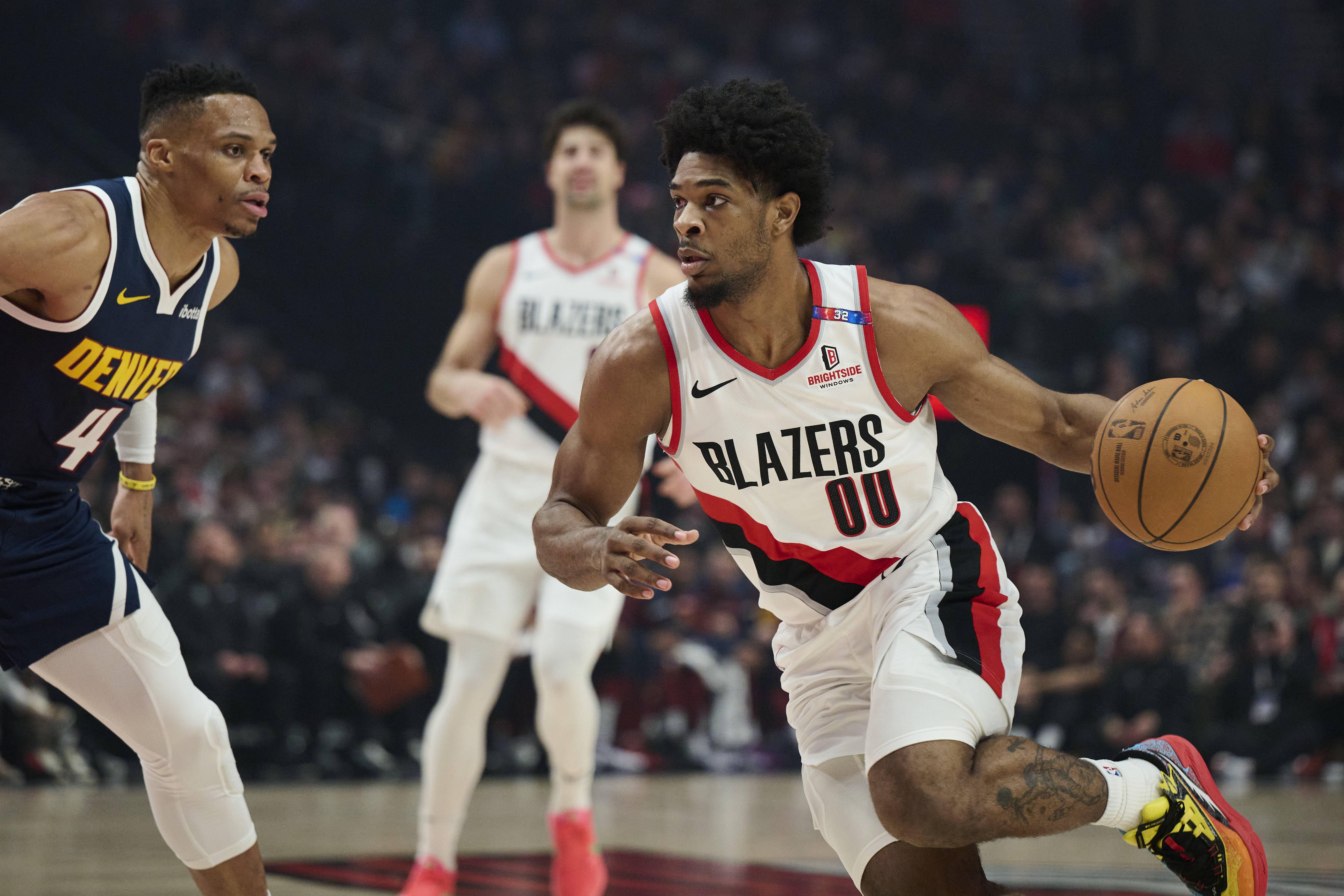Mar 21, 2025; Portland, Oregon, USA; Portland Trail Blazers guard Scoot Henderson (00) drives to the basket during the first half against Denver Nuggets guard Russell Westbrook (4) at Moda Center. Mandatory Credit: Troy Wayrynen-Imagn Images  