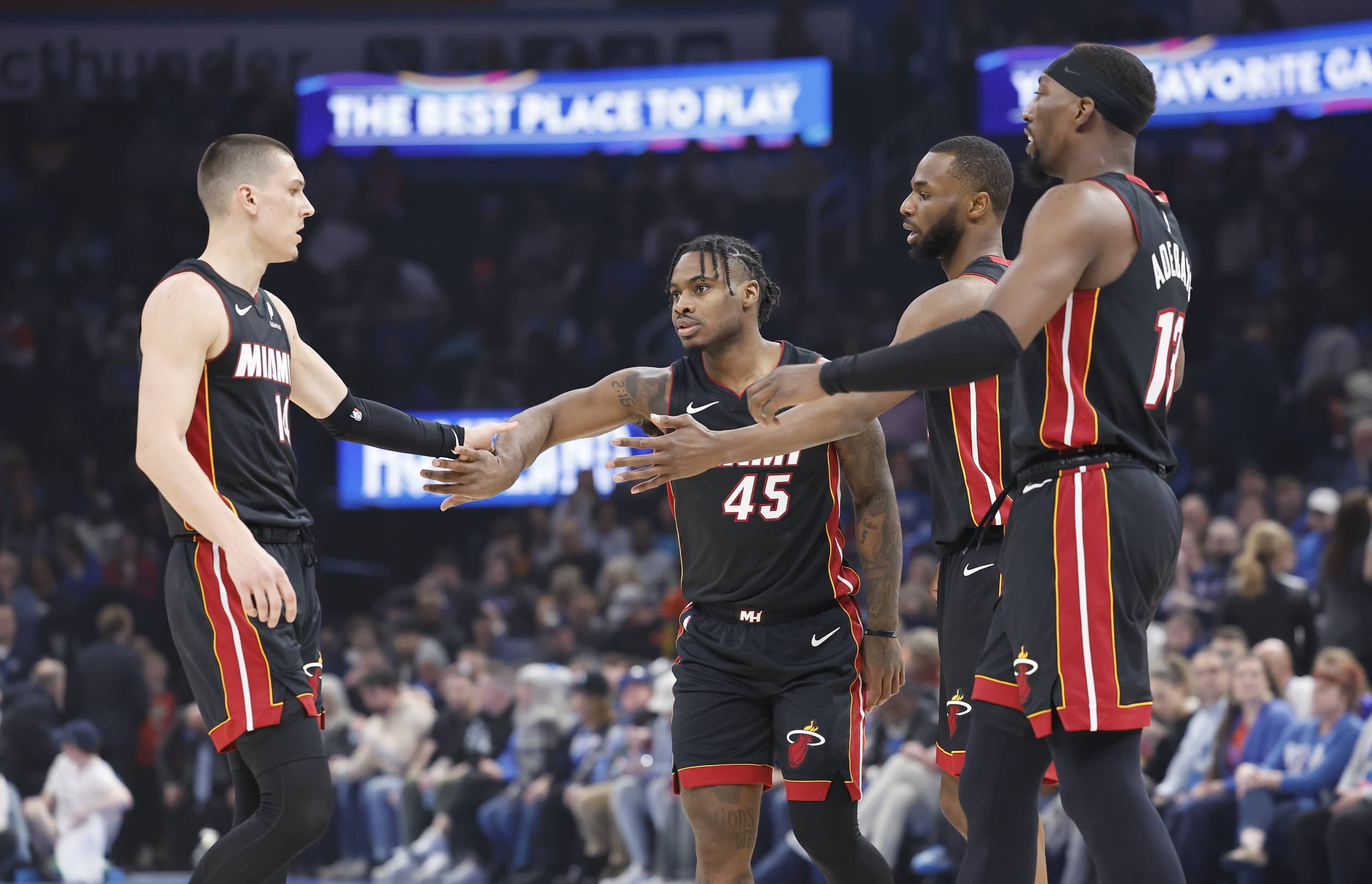 Miami Heat guard Tyler Herro (14), guard Davion Mitchell (45), forward Andrew Wiggins (22) and center Bam Adebayo (13) high five after a play against the Oklahoma City Thunder during the first quarter at Paycom Center.