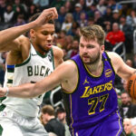 Mar 13, 2025; Milwaukee, Wisconsin, USA; Los Angeles Lakers guard Luka Doncic (77) drives to the basket against Milwaukee Bucks forward Giannis Antetokounmpo (34) in the third quarter at Fiserv Forum. Mandatory Credit: Benny Sieu-Imagn Images