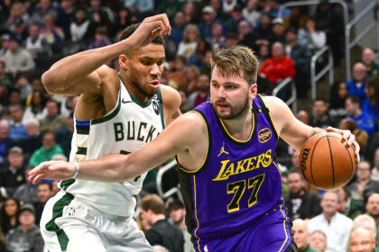 Mar 13, 2025; Milwaukee, Wisconsin, USA; Los Angeles Lakers guard Luka Doncic (77) drives to the basket against Milwaukee Bucks forward Giannis Antetokounmpo (34) in the third quarter at Fiserv Forum. Mandatory Credit: Benny Sieu-Imagn Images