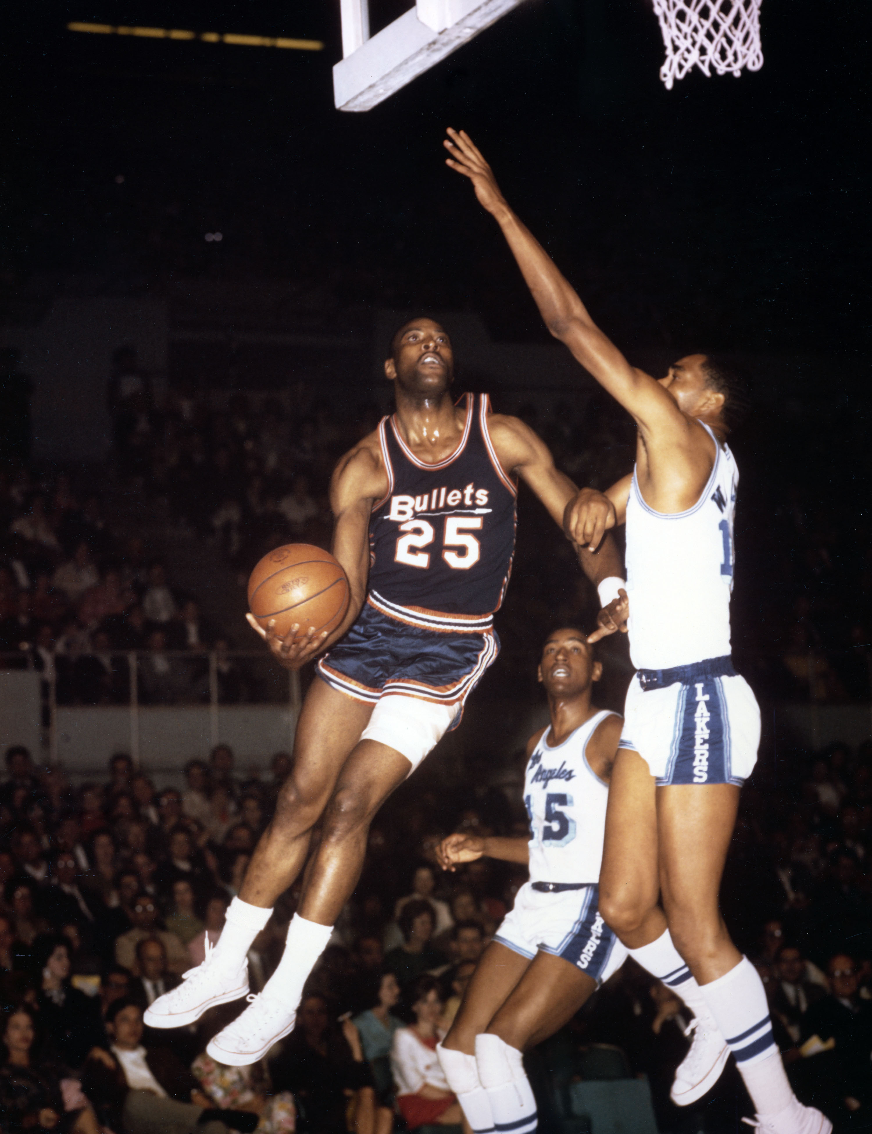 Unknown date; Los Angeles, CA, USA; FILE PHOTO; Baltimore Bullets forward Gus Johnson (25) is defended by Los Angeles Lakers center Gene Wiley (12) at the Los Angeles Sports Arena. Mandatory Credit: Darryl Norenberg-Imagn Images  