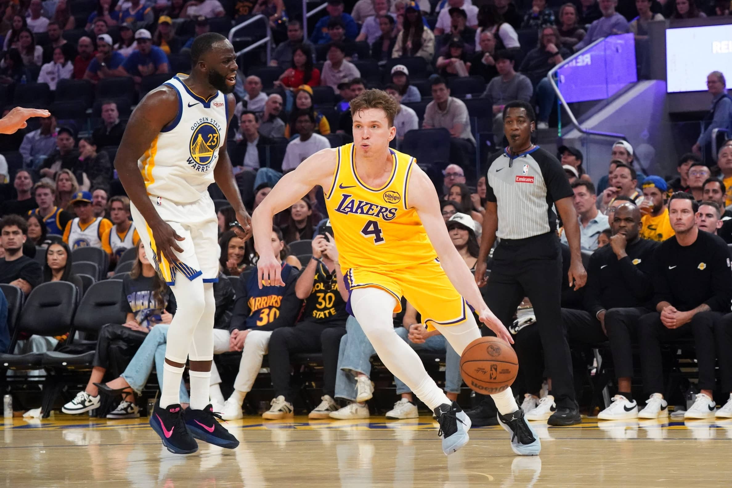 Lakers forward Dalton Knecht dribbles by Warriors forward Draymond Green in the second quarter at Chase Center