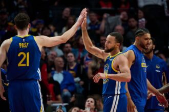 Oct 14, 2025; Portland, Oregon, USA; Golden State Warriors guard Stephen Curry (30) high fives center Quinten Post (21) during the second half against th Portland Trail Blazers at Moda Center. Mandatory Credit: Troy Wayrynen-Imagn Images