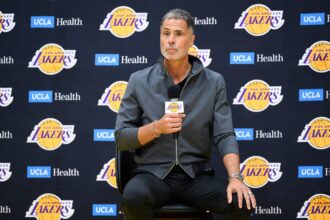 Lakers general manager Rob Pelinka, left, speaks during a press conference to preview the 2025-26 NBA season at UCLA Health Training Center.