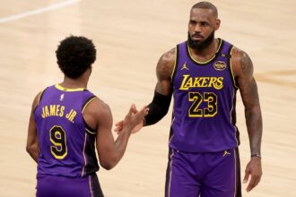 New York, New York, USA; Los Angeles Lakers guard Bronny James (9) checks in for forward LeBron James (23) during the fourth quarter against the New York Knicks at Madison Square Garden. Mandatory Credit: Brad Penner-Imagn Images