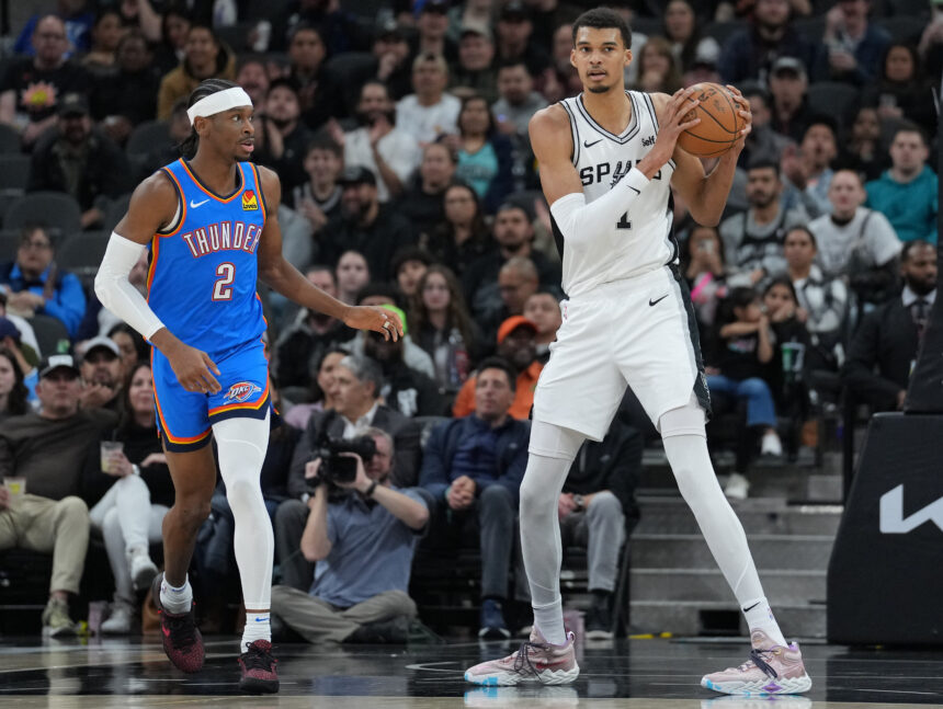 Feb 29, 2024; San Antonio, Texas, USA; San Antonio Spurs center Victor Wembanyama (1) looks down the court beside Oklahoma City Thunder guard Shai Gilgeous-Alexander (2) in the first half at Frost Bank Center. Mandatory Credit: Daniel Dunn-Imagn Images