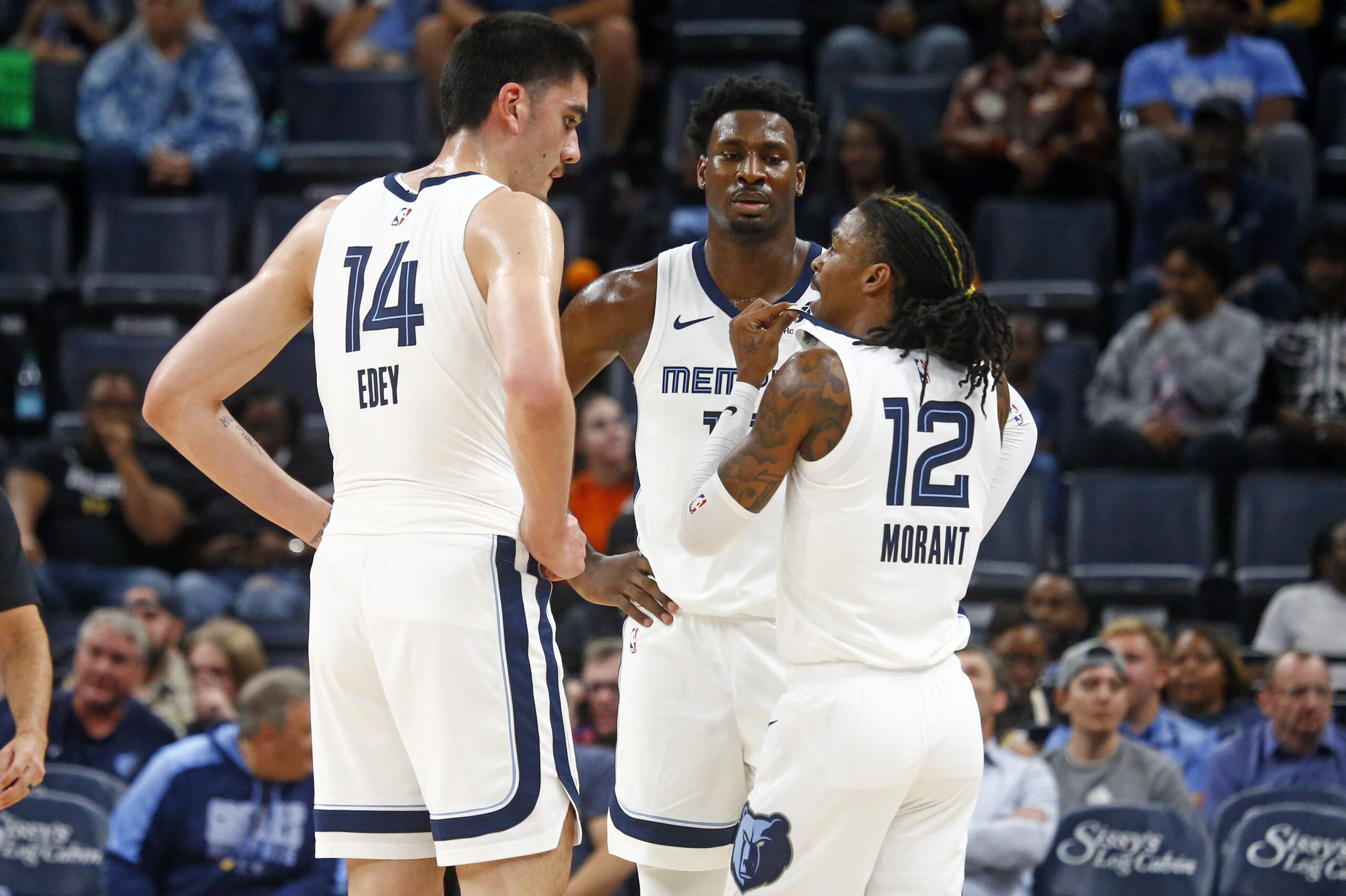 Oct 30, 2024; Memphis, Tennessee, USA; Memphis Grizzlies guard Ja Morant (12) talks with center Zach Edey (14) and forward Jaren Jackson Jr. (13) during the first half against the Brooklyn Nets at FedExForum. Mandatory Credit: Petre Thomas-Imagn Images