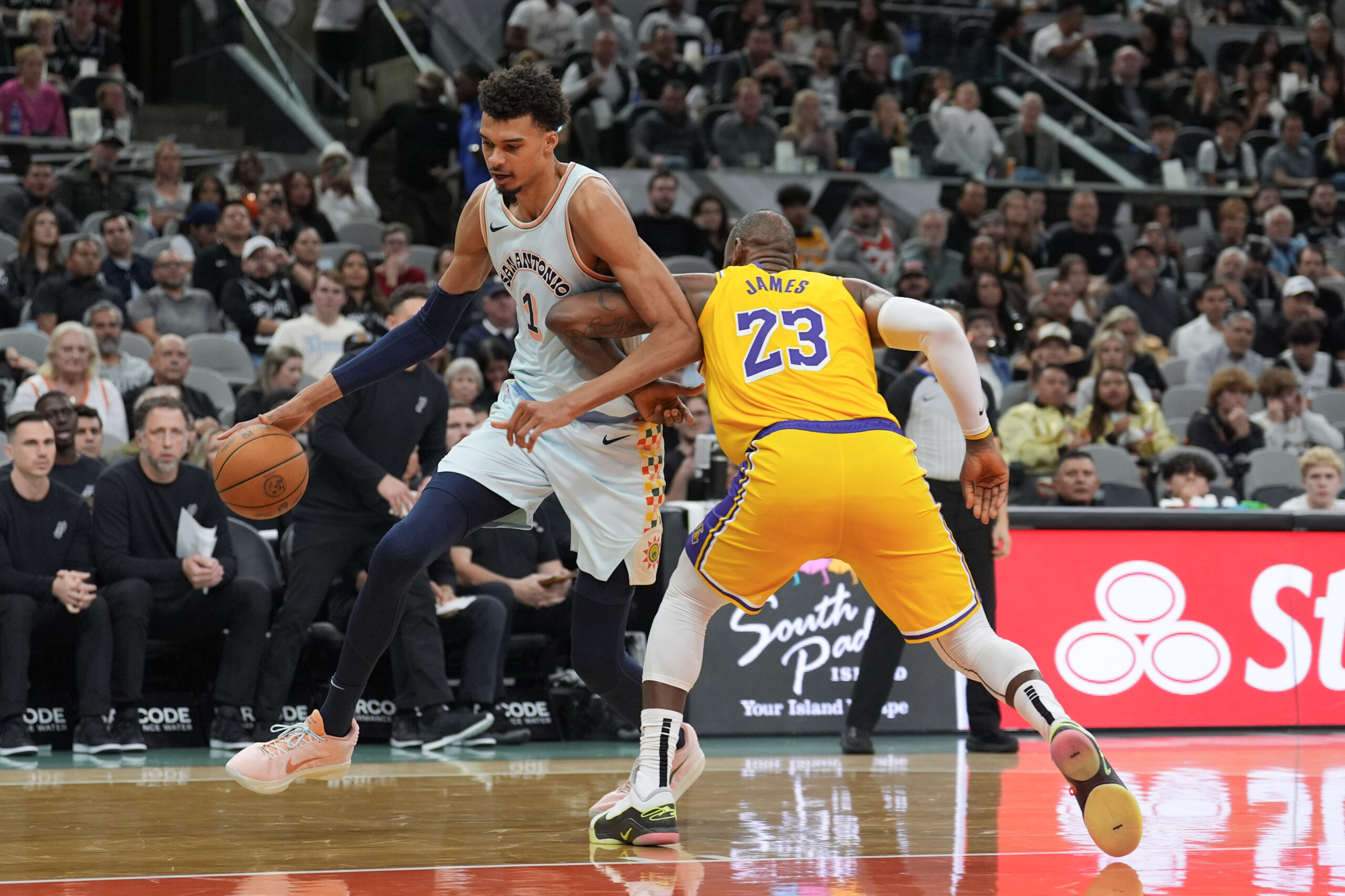 Nov 27, 2024; San Antonio, Texas, USA; San Antonio Spurs center Victor Wembanyama (1) dribbles past Los Angeles Lakers forward LeBron James (23) in the first half at Frost Bank Center. Mandatory Credit: Daniel Dunn-Imagn Images