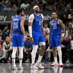 Mar 31, 2025; Dallas, Texas, USA; Dallas Mavericks guard Spencer Dinwiddie (26) and forward P.J. Washington (25) check on center Daniel Gafford (21) during the second half against the Brooklyn Nets at the American Airlines Center. Mandatory Credit: Jerome Miron-Imagn Images