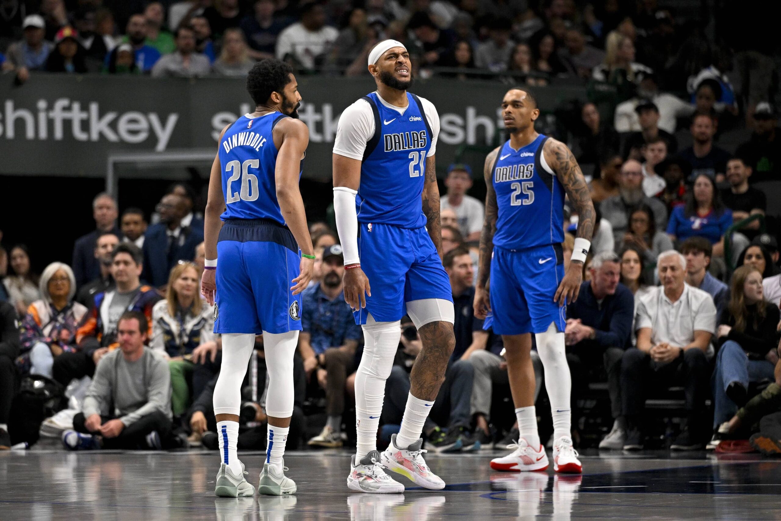 Mar 31, 2025; Dallas, Texas, USA; Dallas Mavericks guard Spencer Dinwiddie (26) and forward P.J. Washington (25) check on center Daniel Gafford (21) during the second half against the Brooklyn Nets at the American Airlines Center. Mandatory Credit: Jerome Miron-Imagn Images