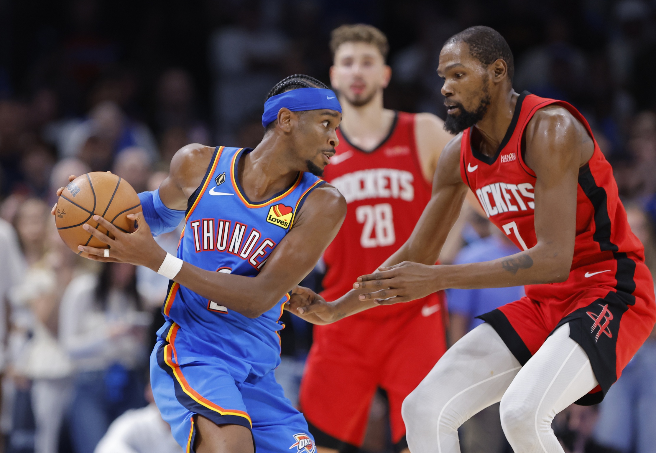 Oct 21, 2025; Oklahoma City, Oklahoma, USA; Oklahoma City Thunder guard Shai Gilgeous-Alexander (2) keeps the ball away from Houston Rockets forward Kevin Durant (7) during the second half at Paycom Center. Mandatory Credit: Alonzo Adams-Imagn Images