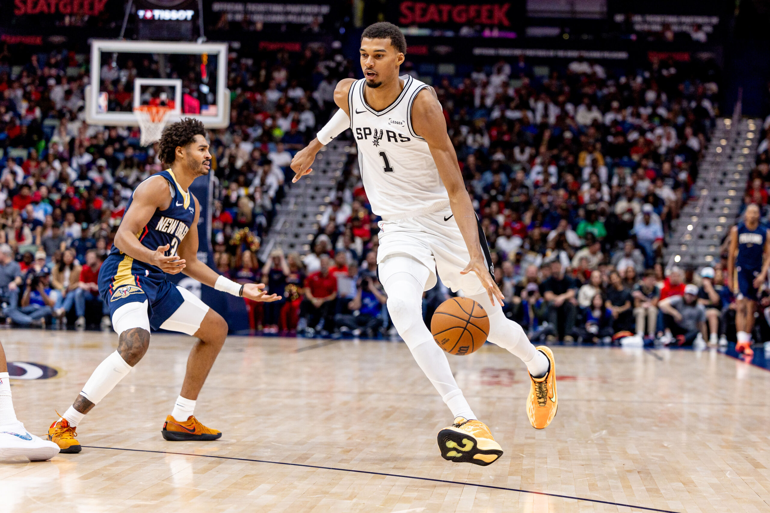 Oct 24, 2025; New Orleans, Louisiana, USA; San Antonio Spurs forward/center Victor Wembanyama (1) dribbles against New Orleans Pelicans guard Jordan Poole (3) during the first half at Smoothie King Center. Mandatory Credit: Stephen Lew-Imagn Images