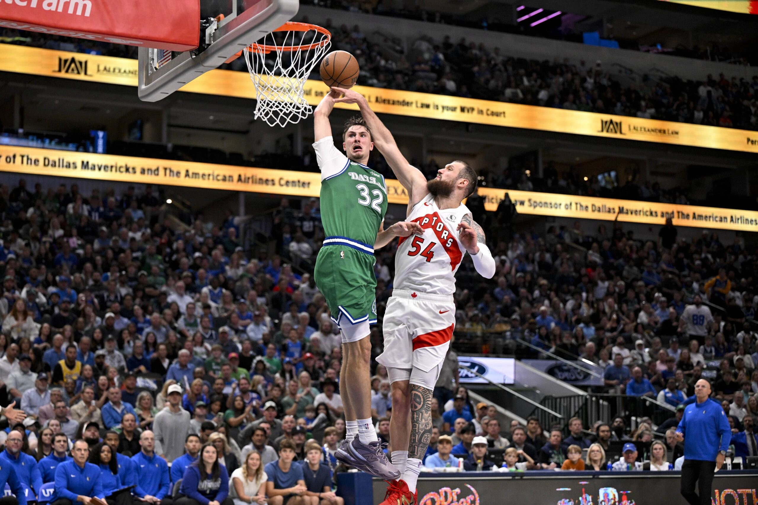 Oct 26, 2025; Dallas, Texas, USA; Dallas Mavericks forward Cooper Flagg (32) dunks the ball past Toronto Raptors forward Sandro Mamukelashvili (54) during the third quarter at the American Airlines Center. Mandatory Credit: Jerome Miron-Imagn Images