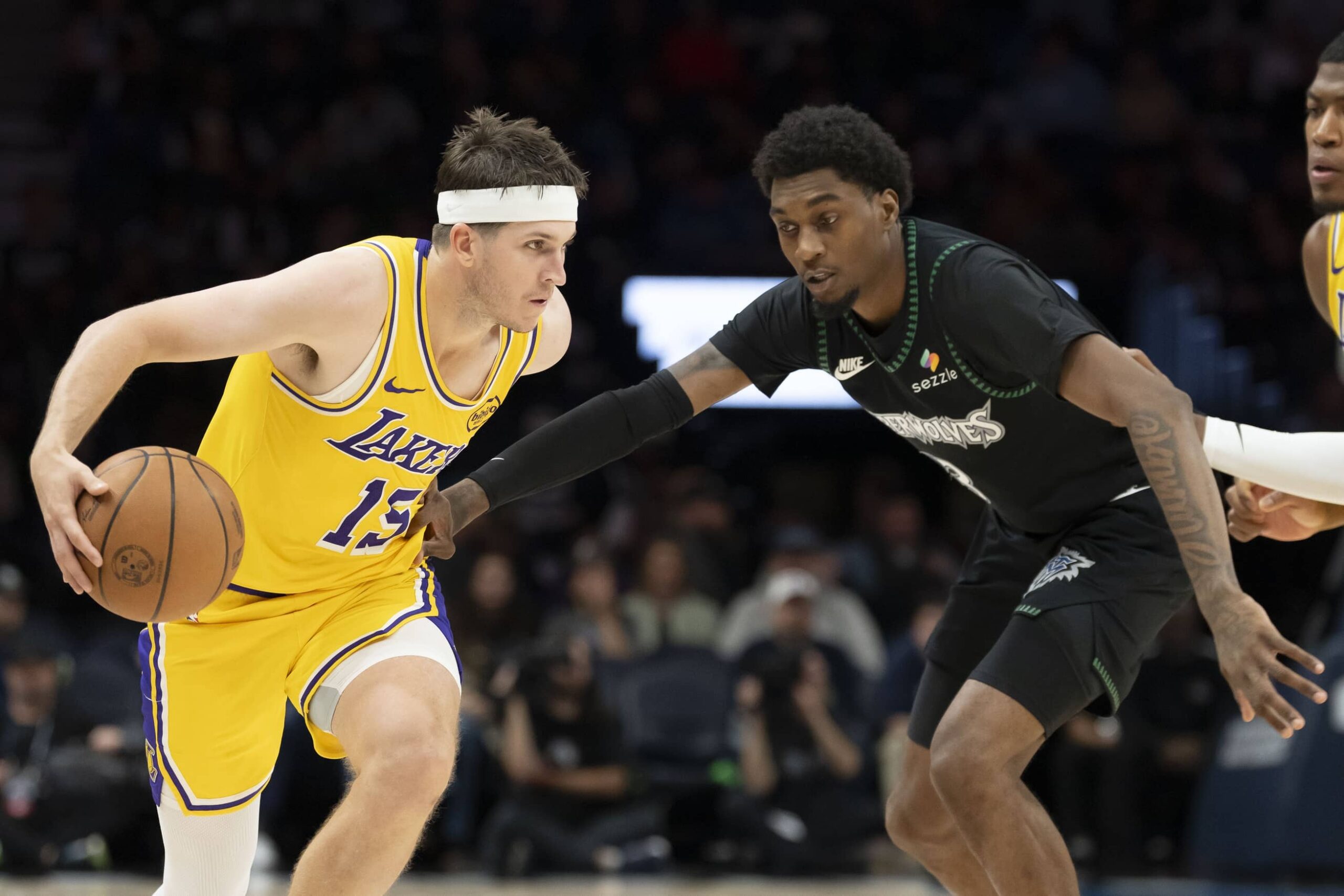 Oct 29, 2025; Minneapolis, Minnesota, USA; Los Angeles Lakers guard Austin Reaves (15) dribbles the ball past Minnesota Timberwolves forward Jaden McDaniels (3) in the second half at Target Center. Mandatory Credit: Jesse Johnson-Imagn Images