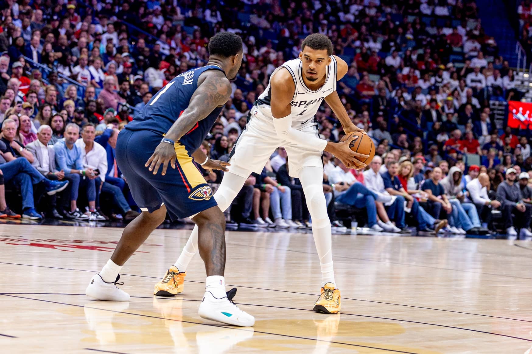 Spurs forward/center Victor Wembanyama dribbles against Pelicans forward Zion Williamson during the first half at Smoothie King Center