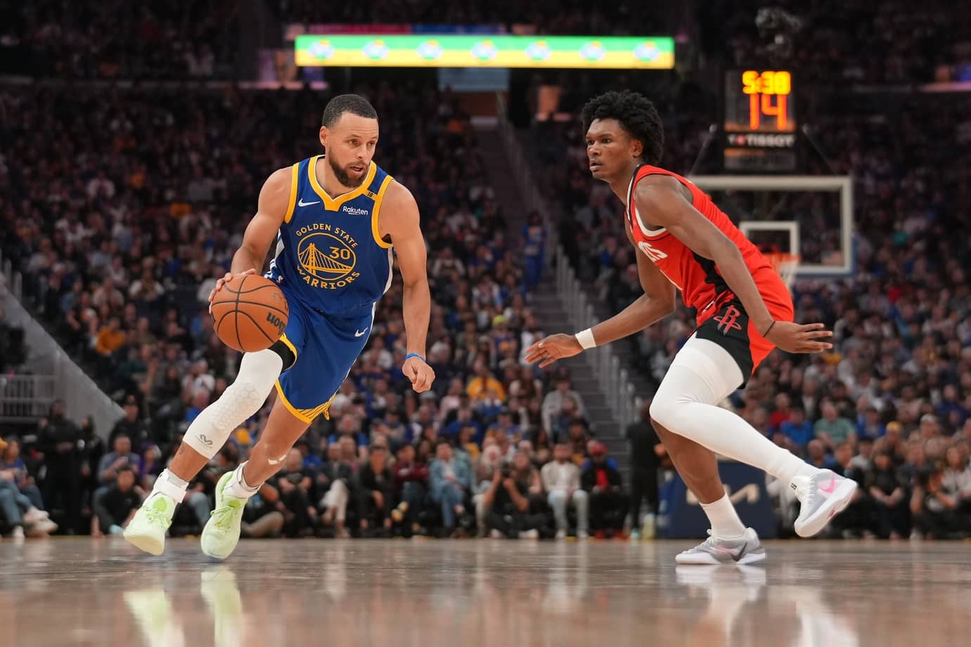 San Francisco, California, USA; Golden State Warriors guard Stephen Curry (30) dribbles past Houston Rockets forward Amen Thompson (1) in the second quarter at the Chase Center. Mandatory Credit: Cary Edmondson-Imagn Images
