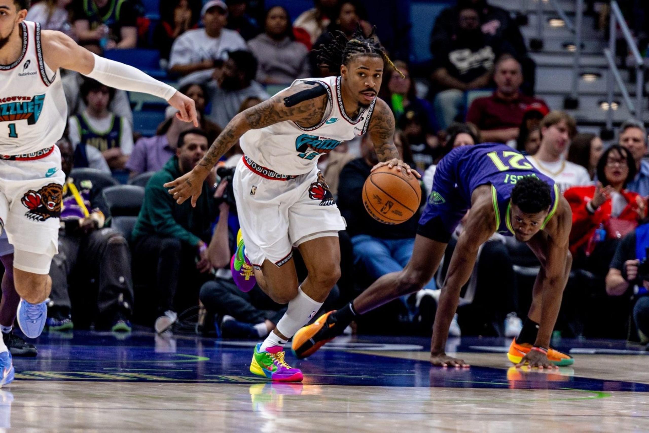 Mar 9, 2025; New Orleans, Louisiana, USA; Memphis Grizzlies guard Ja Morant (12) brings the ball up court against New Orleans Pelicans center Yves Missi (21) during the second half at Smoothie King Center. Mandatory Credit: Stephen Lew-Imagn Images