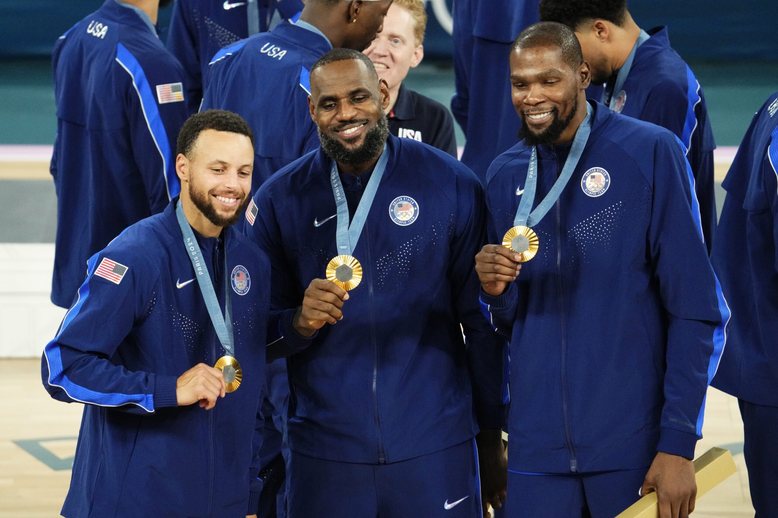 Aug 10, 2024; Paris, France; United States shooting guard Stephen Curry (4) and guard LeBron James (6) and guard Kevin Durant (7) celebrate with their gold medals on the podium after defeating France in the men's basketball gold medal game during the Paris 2024 Olympic Summer Games at Accor Arena. Mandatory Credit: Rob Schumacher-USA TODAY Sports