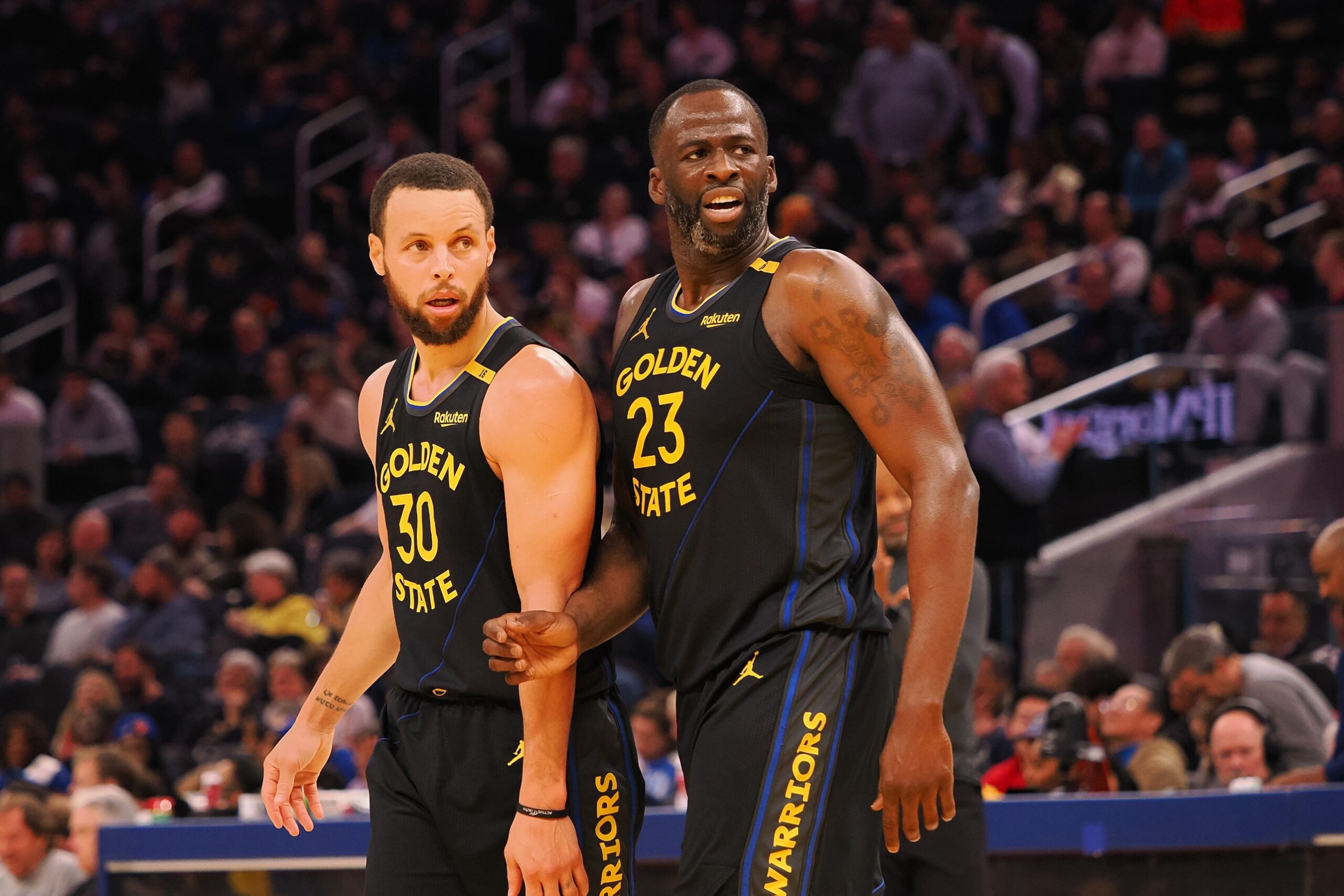 Feb 3, 2025; San Francisco, California, USA; Golden State Warriors guard Stephen Curry (30) and forward Draymond Green (23) look towards an Orlando Magic player at half time at Chase Center. Mandatory Credit: Kelley L Cox-Imagn Images