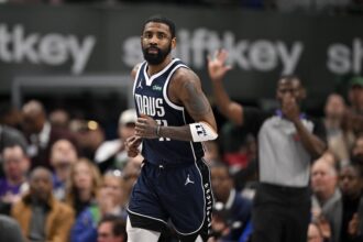 Dallas, Texas, USA; Dallas Mavericks guard Kyrie Irving (11) smiles after he makes a basket against the Golden State Warriors during the second quarter at the American Airlines Center. Mandatory Credit: Jerome Miron-Imagn Images