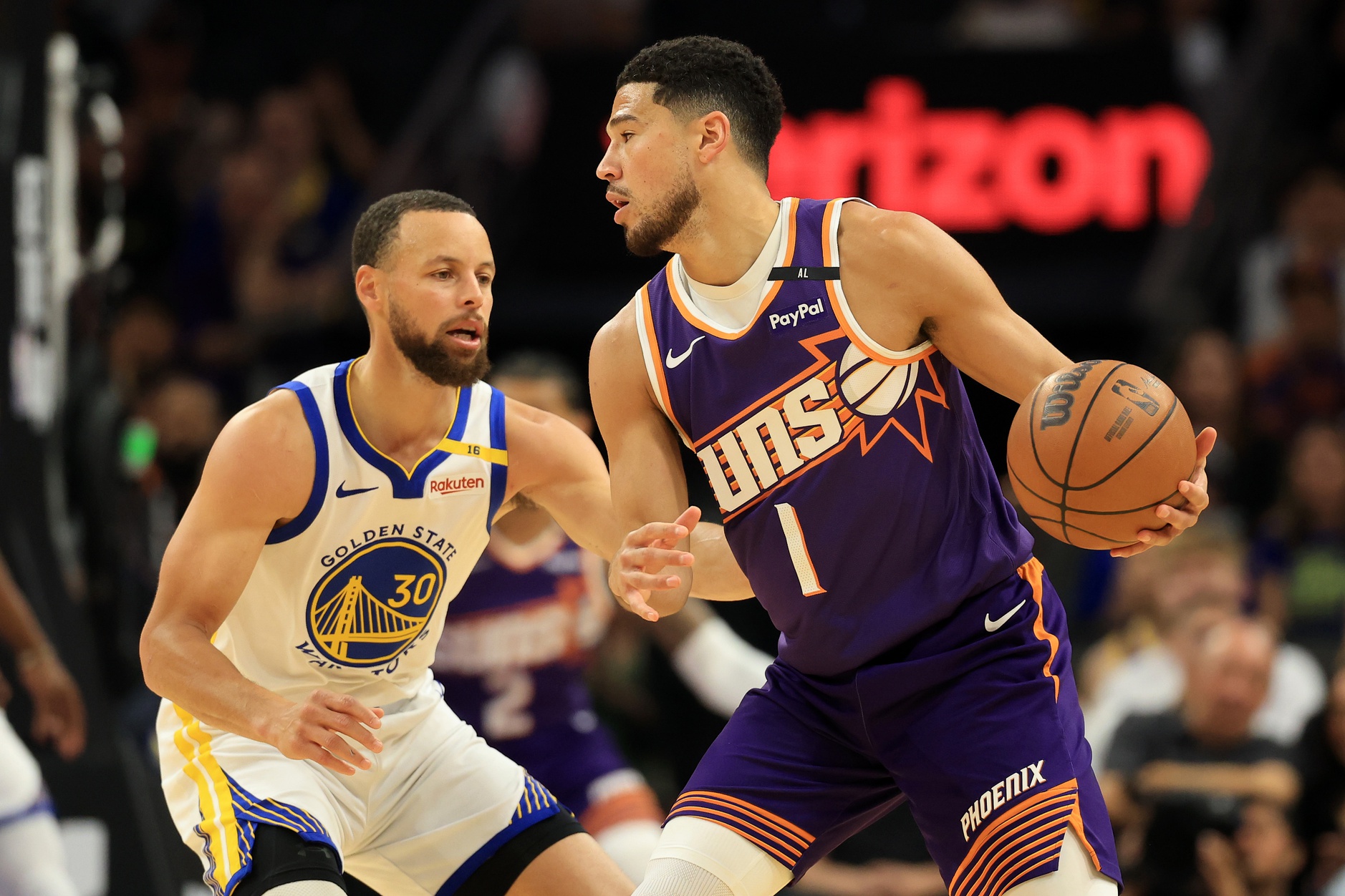 Apr 8, 2025; Phoenix, Arizona, USA; Phoenix Suns guard Devin Booker (1) dribbles the ball agisasnt Golden State Warriors guard Stephen Curry (30) during the first half at Footprint Center. Mandatory Credit: Mark J. Rebilas-Imagn Images