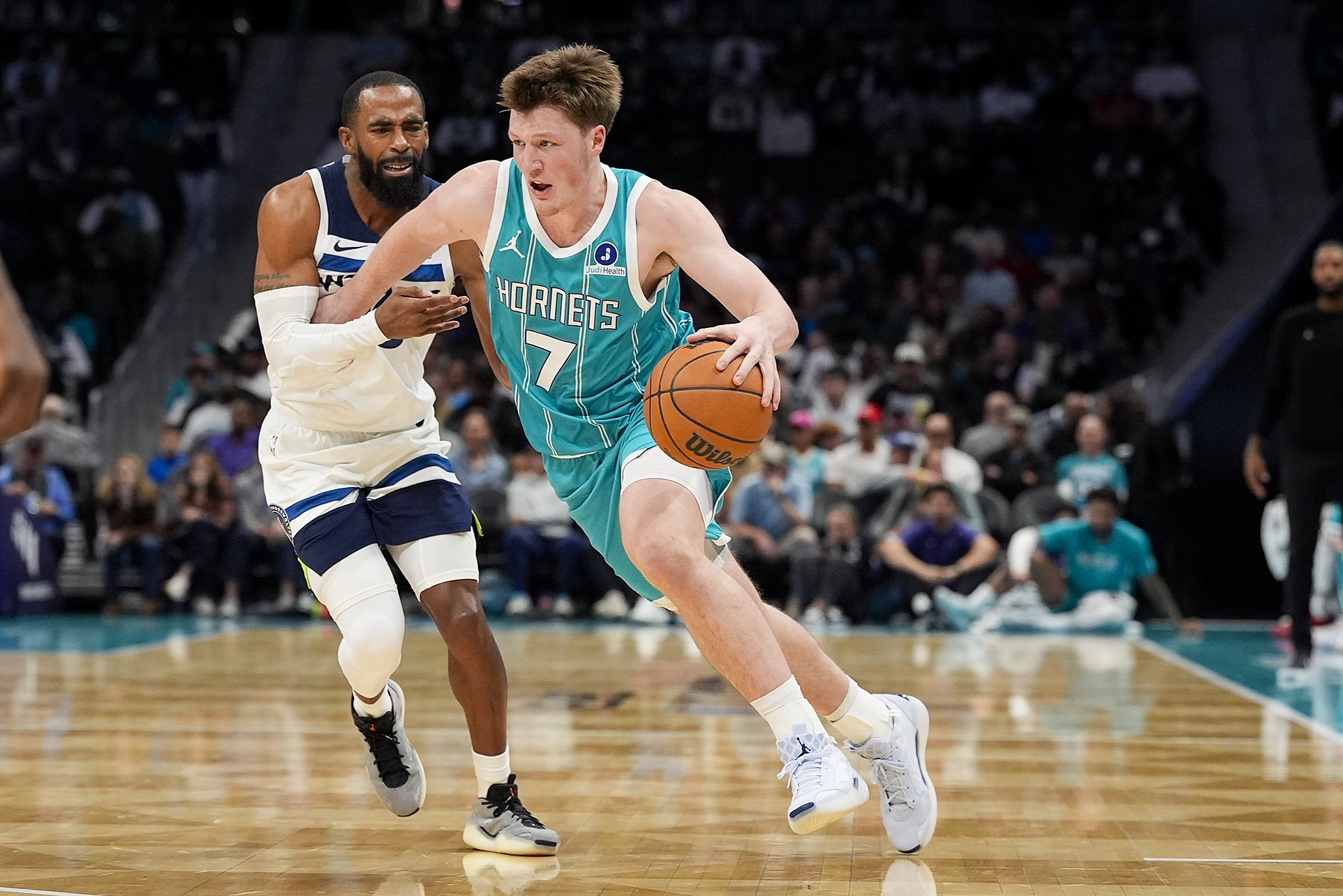 Nov 1, 2025; Charlotte, North Carolina, USA; Charlotte Hornets guard Kon Knueppel (7) handles the ball against Minnesota Timberwolves guard Mike Conley (10) during the second quarter at Spectrum Center. Mandatory Credit: Jim Dedmon-Imagn Images