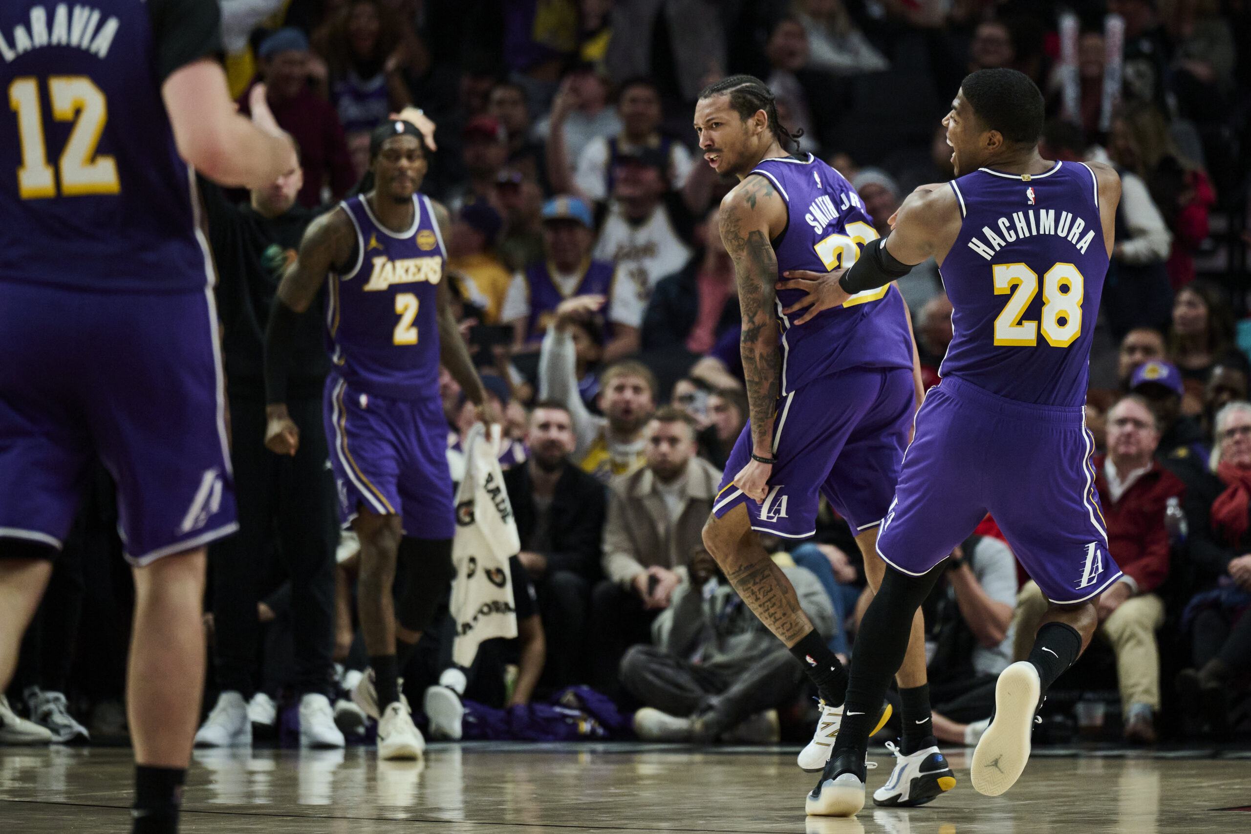 Nov 3, 2025; Portland, Oregon, USA; Los Angeles Lakers guard Nick Smith Jr. (20) reacts with teammate forward Rui Hachimura (28) after scoring a basket during the second half against the Portland Trail Blazers at Moda Center. Mandatory Credit: Troy Wayrynen-Imagn Images
