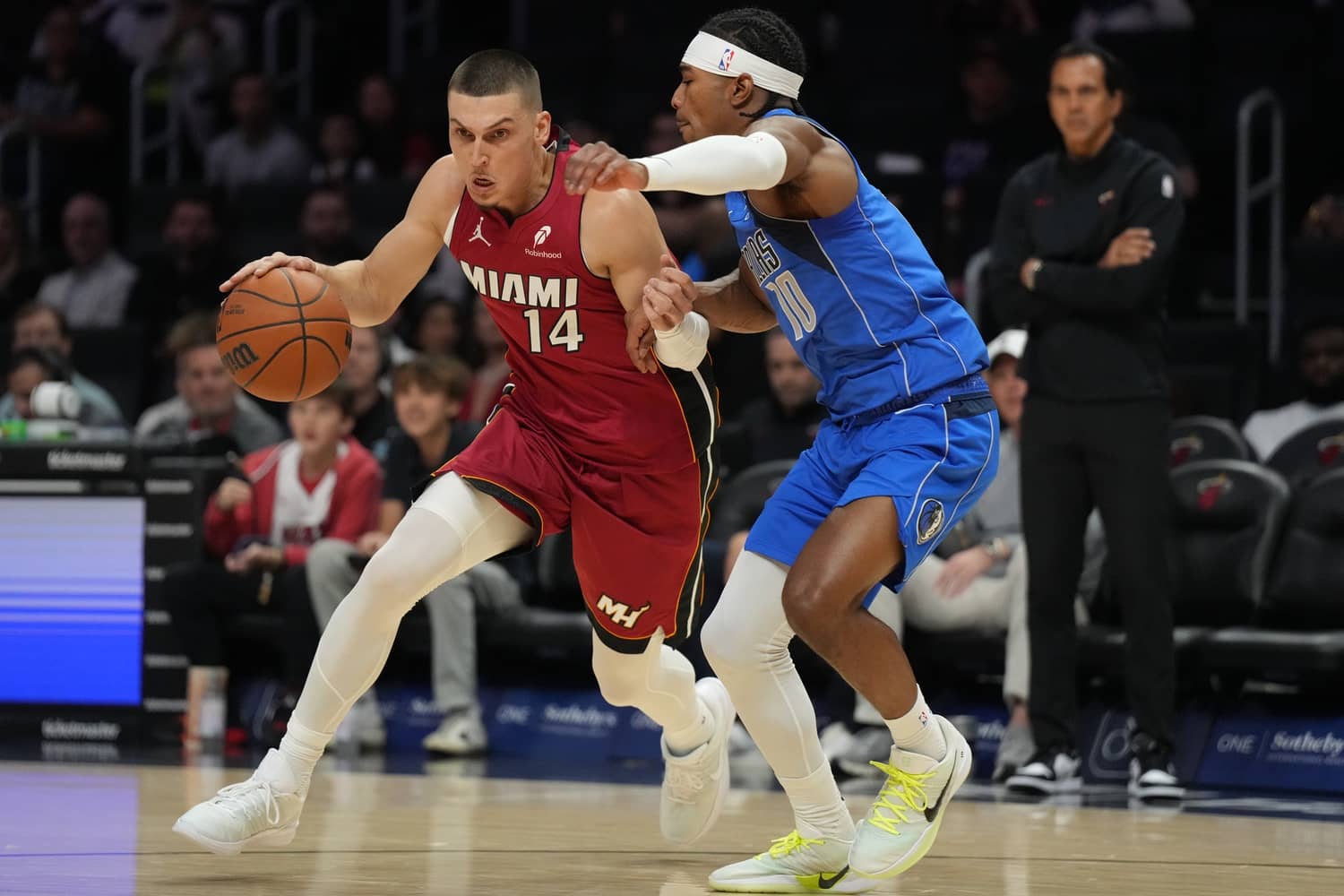 Nov 24, 2025; Miami, Florida, USA; Miami Heat guard Tyler Herro (14) drives to the basket as Dallas Mavericks guard Brandon Williams (10) defends during the first half at Kaseya Center. Mandatory Credit: Jim Rassol-Imagn Images