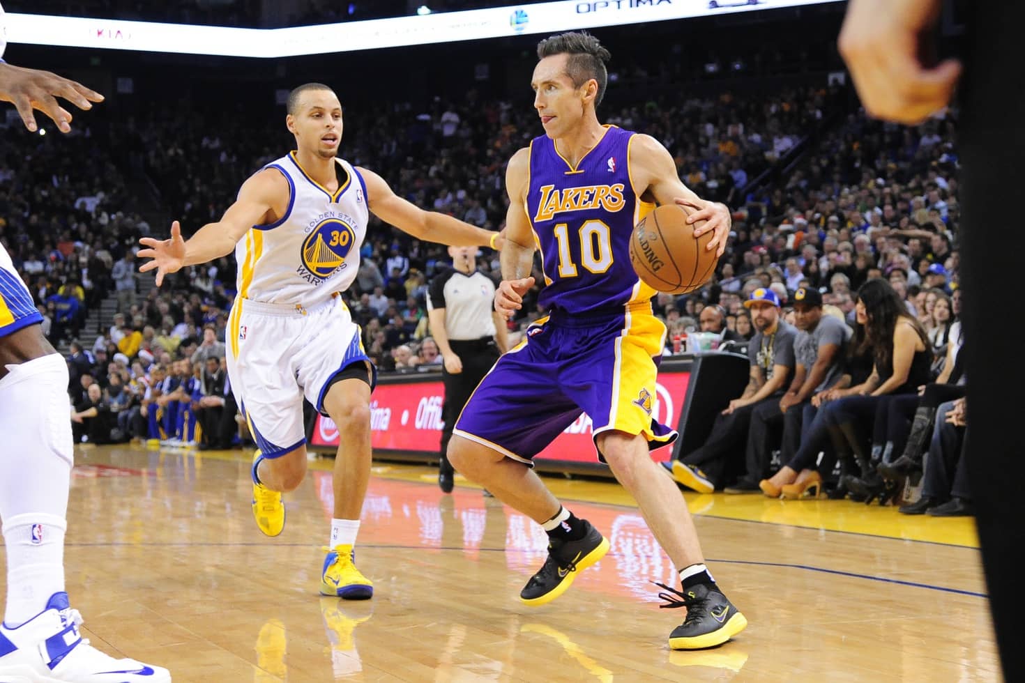 Los Angeles Lakers point guard Steve Nash (10) dribbles the ball against Golden State Warriors point guard Stephen Curry (30) during the first quarter at ORACLE Arena.