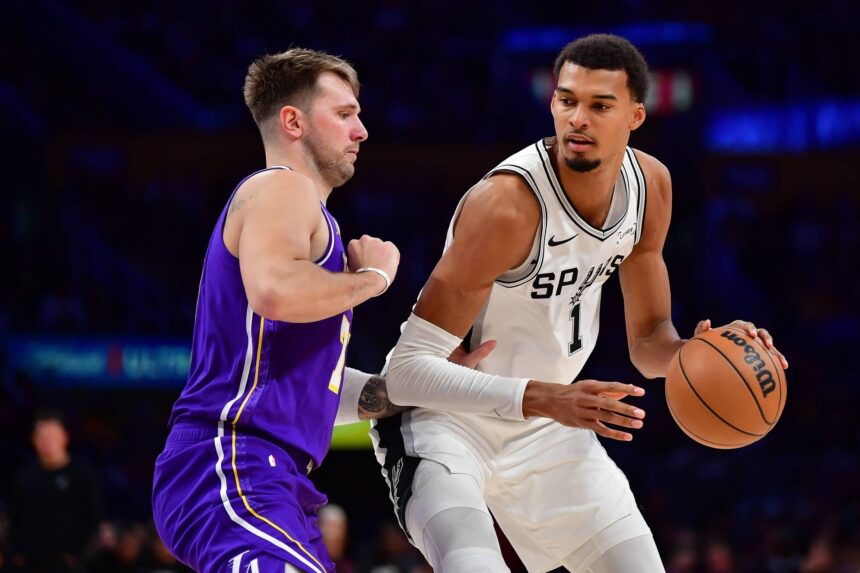 San Antonio Spurs forward Victor Wembanyama (1) moves the ball against Los Angeles Lakers guard Luka Doncic (77) during the second half at Crypto.com Arena.