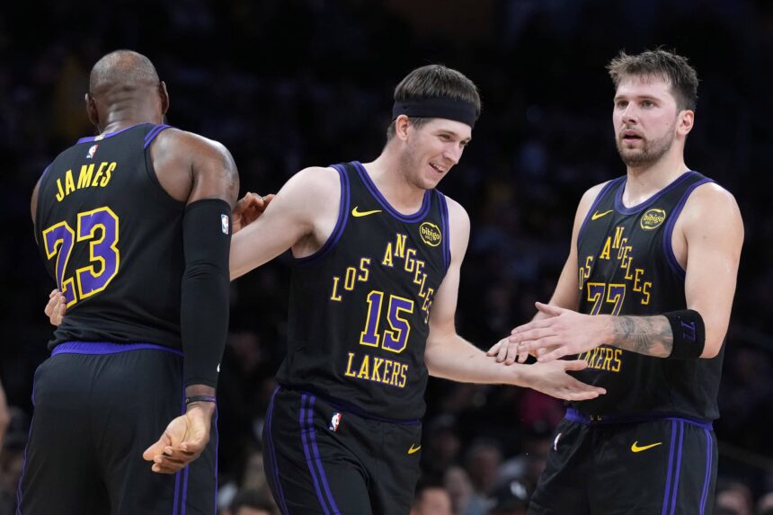 Los Angeles, California, USA; Los Angeles Lakers guard Austin Reaves (15) is congratulated by forward LeBron James (23) and guard Luka Doncic (77) after a three-point basket in the second quarter at Crypto.com Arena. Mandatory Credit: Kirby Lee-Imagn Images