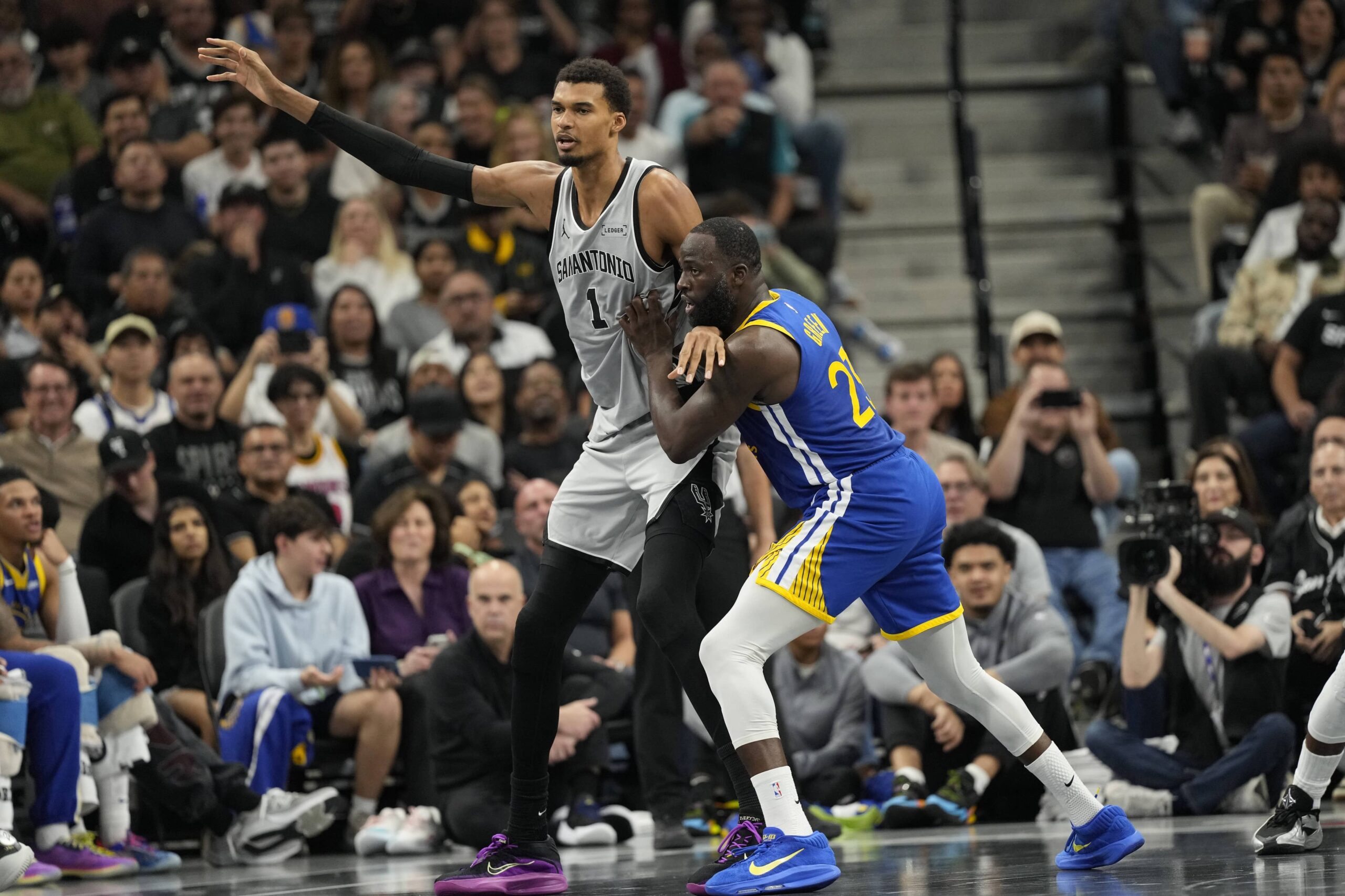 San Antonio, Texas, USA; San Antonio Spurs forward Victor Wembanyama (1) posts up on Golden State Warriors forward Draymond Green (23) during the first half at Frost Bank Center. Mandatory Credit: Scott Wachter-Imagn Images
