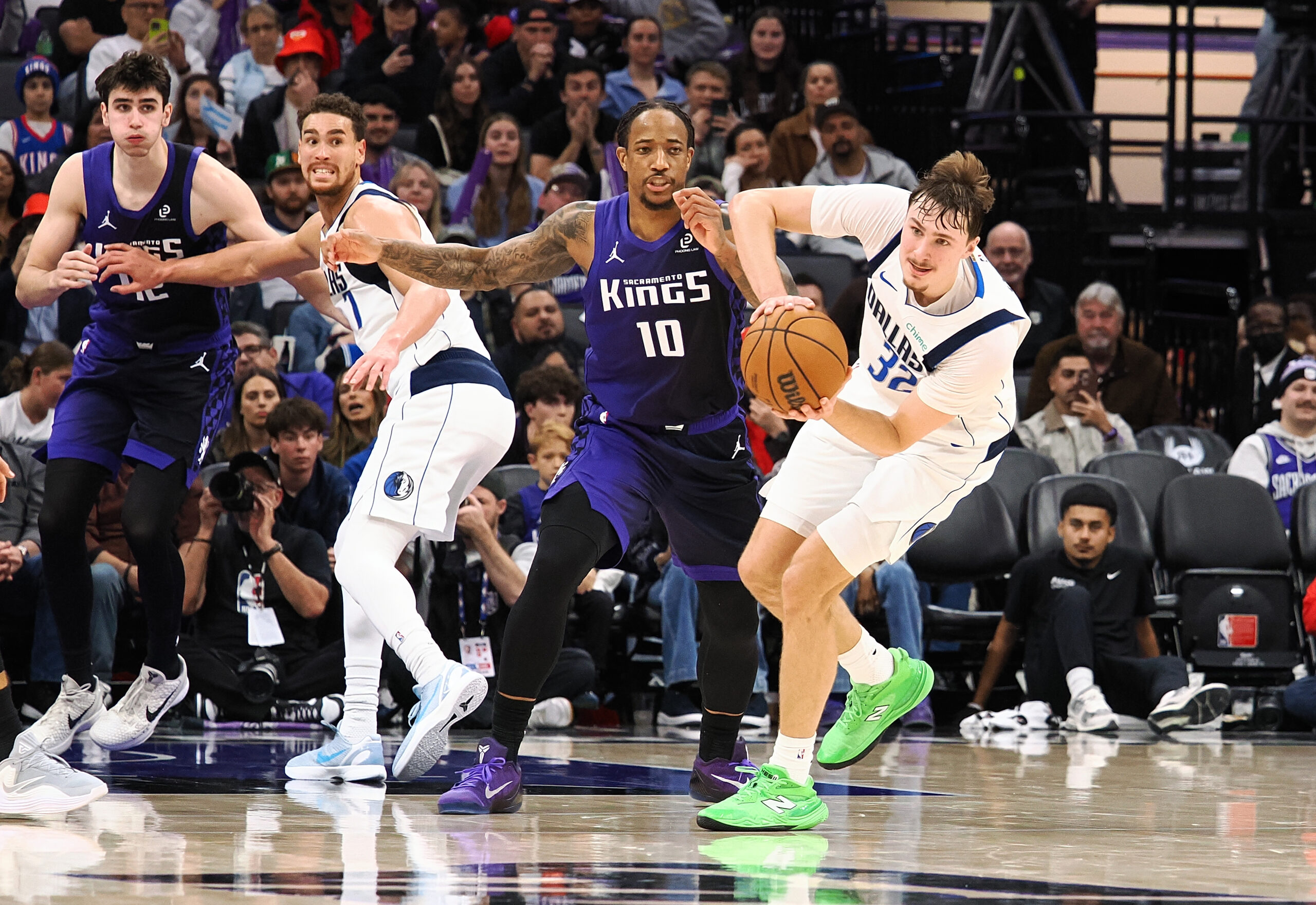 Dec 27, 2025; Sacramento, California, USA; Dallas Mavericks forward/guard Cooper Glagg (32) looks to pass the ball against Sacramento Kings forward/guard DeMar DeRozan (10) during the fourth quarter at Golden 1 Center. Mandatory Credit: Kelley L Cox-Imagn Images