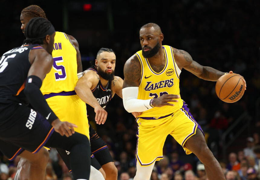 Dec 23, 2025; Phoenix, Arizona, USA; Los Angeles Lakers forward LeBron James (23) moves the ball against Phoenix Suns forward Dillon Brooks in the second half at Mortgage Matchup Center. Mandatory Credit: Mark J. Rebilas-Imagn Images